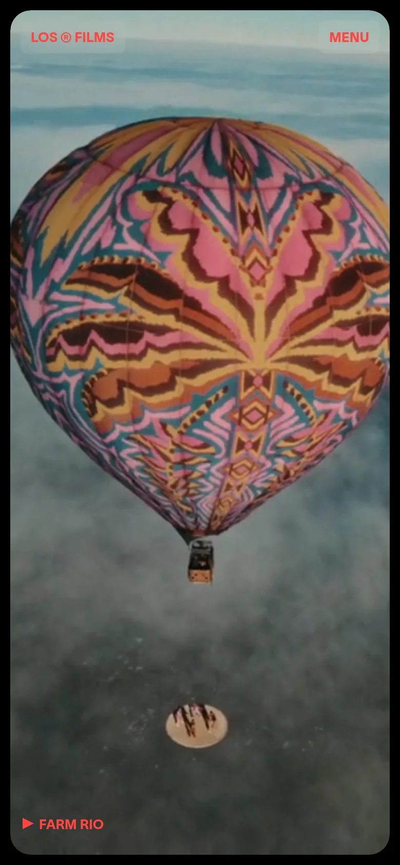 Los Films mobile homepage with a vertically stacked layout centered on a large, colorful hot air balloon imagery. The interface uses a simplified top navigation with a prominent menu button and a single call-to-action for Farm Rio at the bottom.
