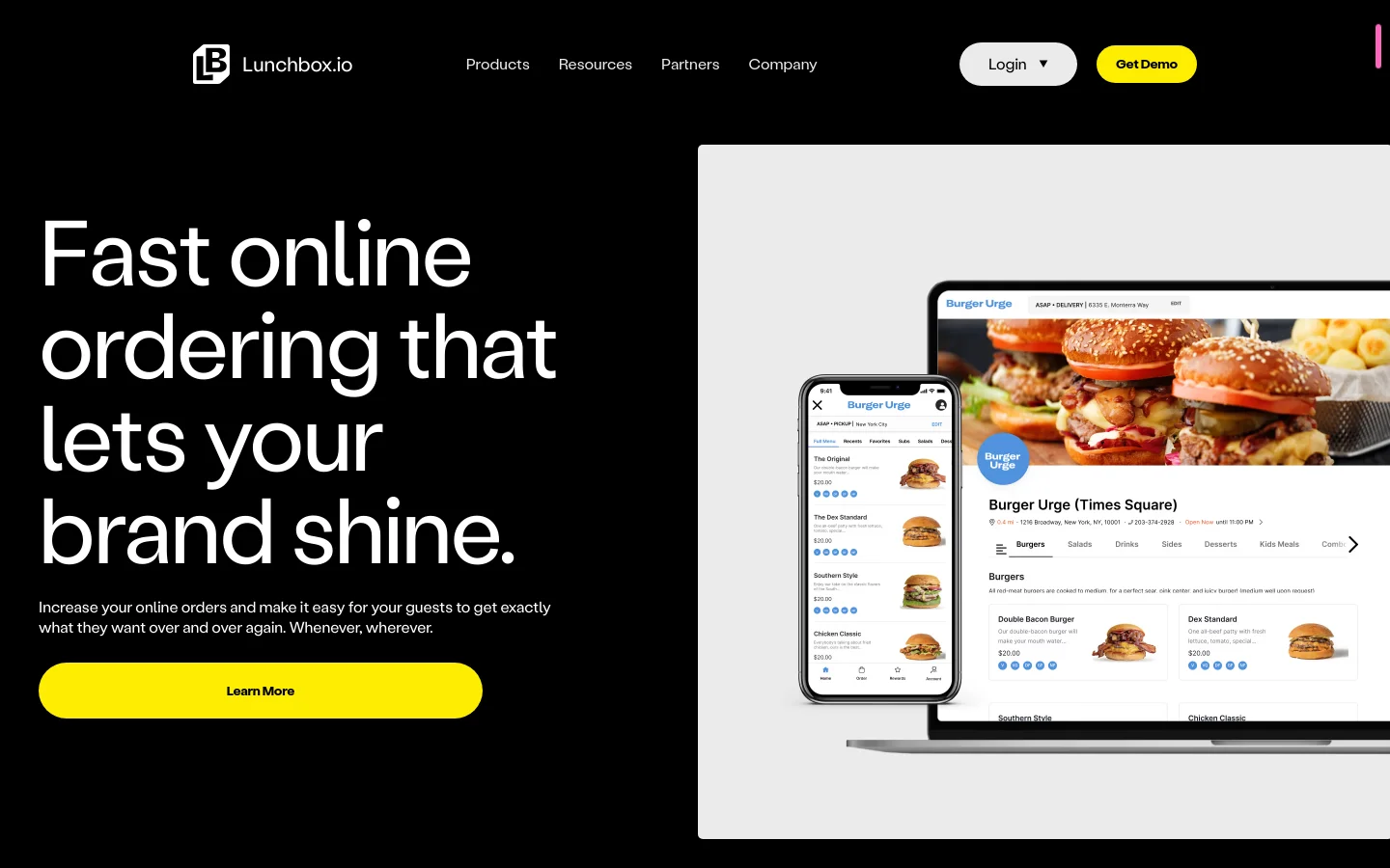 The desktop landing page features a high-contrast black background with large white headline text reading 'Fast online ordering that lets your brand shine.' A bright yellow 'Learn More' button sits below a brief subheadline, while the right side displays a large graphic of a laptop and smartphone showing a food ordering interface. The top navigation bar includes the Lunchbox.io logo, menu links, and yellow 'Get Demo' and white 'Login' buttons.