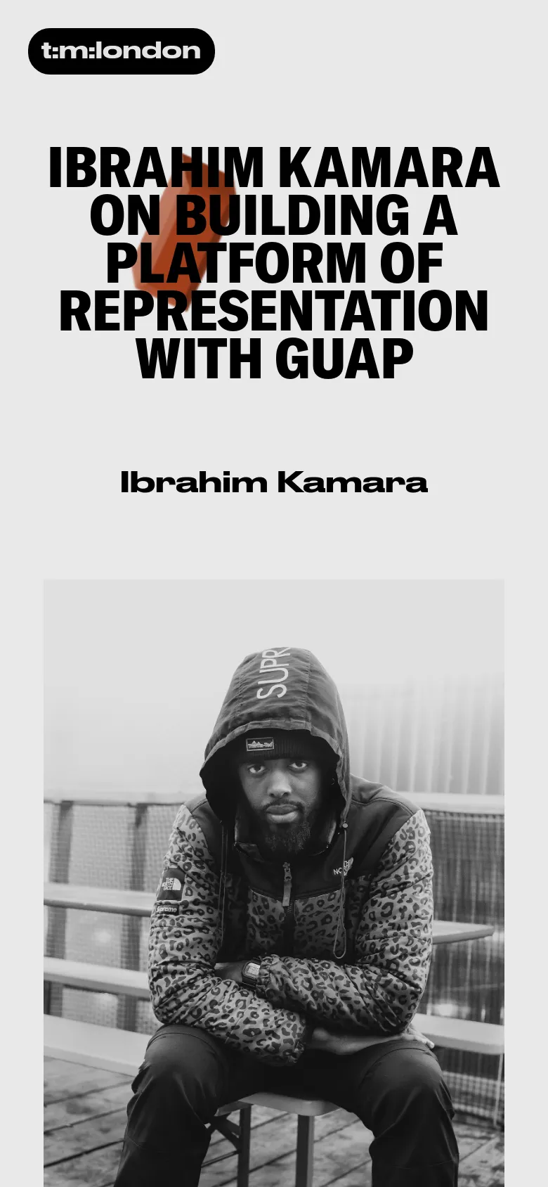 The mobile view presents a vertically stacked layout starting with a black pill-shaped 't:m:london' button. Below this, the large bold headline is centered over a red brick texture, followed by the subject's name 'Ibrahim Kamara' and a large black and white portrait of a man wearing a patterned hoodie.
