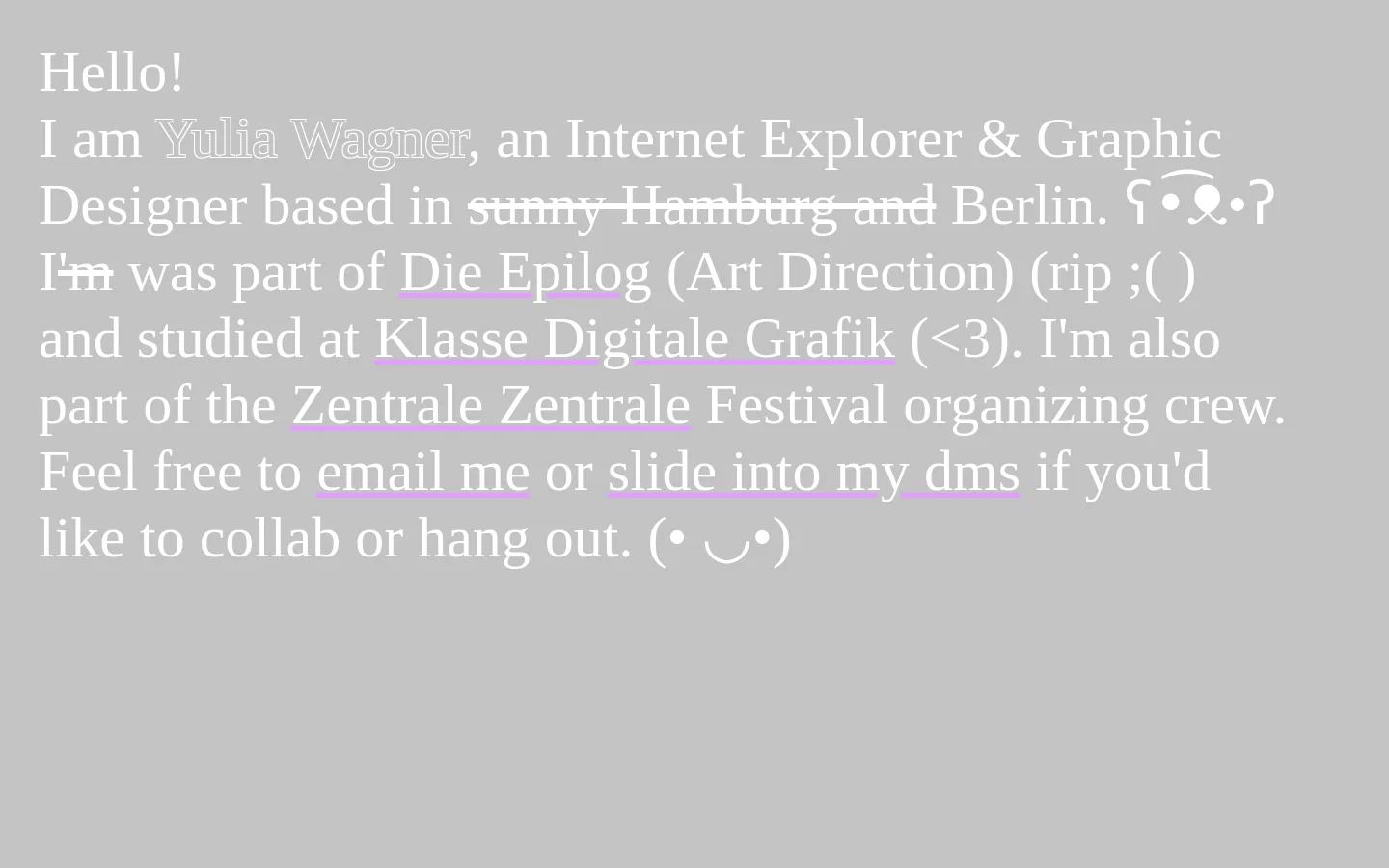 A minimalist personal website with a solid grey background and white serif typography. The text introduces Yulia Wagner, an Internet Explorer and Graphic Designer, and includes several underlined text links for email and social media. The layout is centered and spacious, featuring playful kaomoji icons.