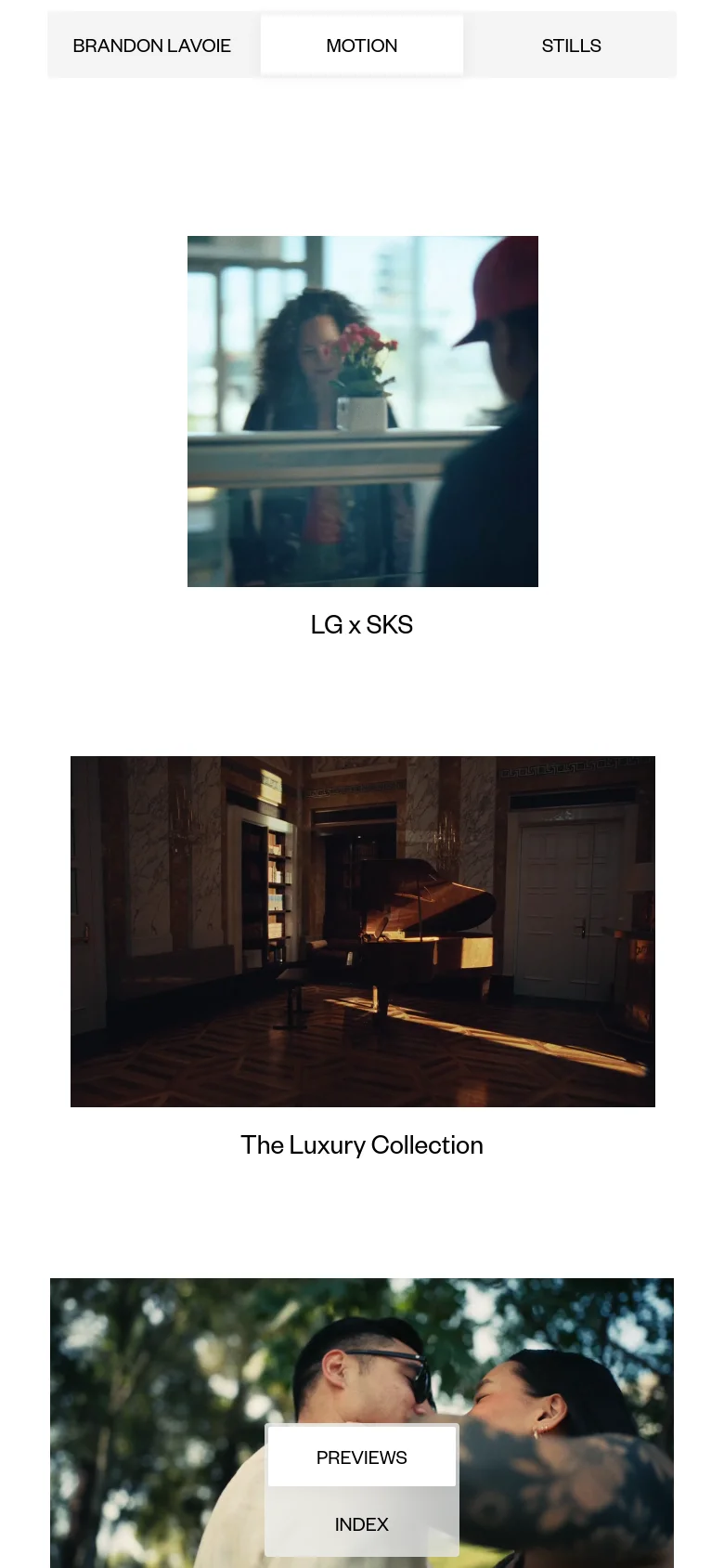 The mobile version maintains the minimalist white aesthetic and top navigation but stacks the content vertically. The video thumbnails appear larger and single-column, with the 'PREVIEWS' and 'INDEX' buttons centered as floating overlays on the bottom images.