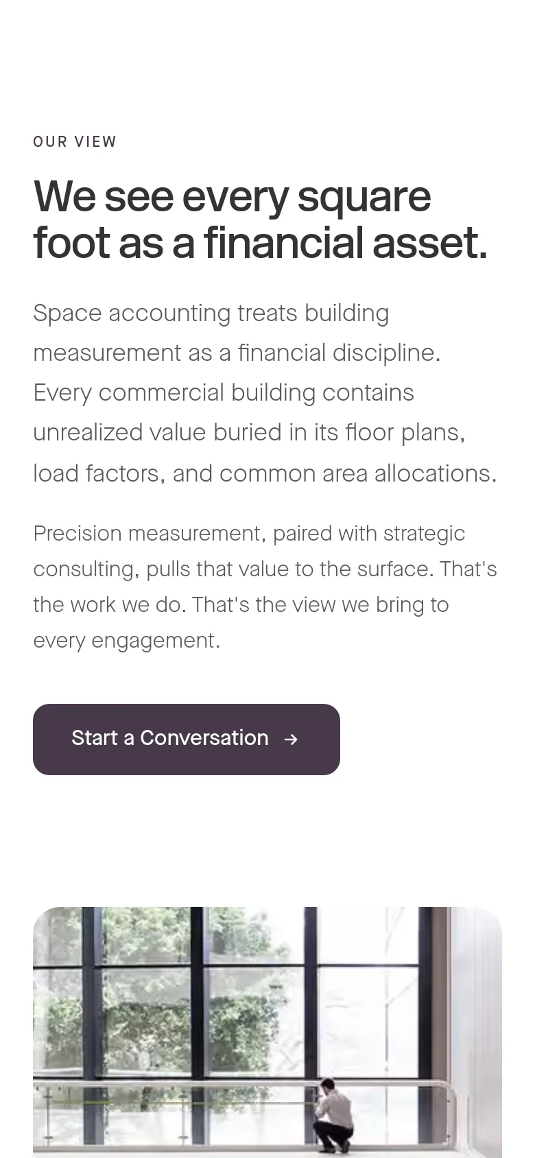The mobile version uses a single-column vertical layout with the same headline and text, but the font sizes are adjusted for smaller screens. The 'Start a Conversation' button is centered, and the large office interior photograph is scaled down to fit the narrow width.