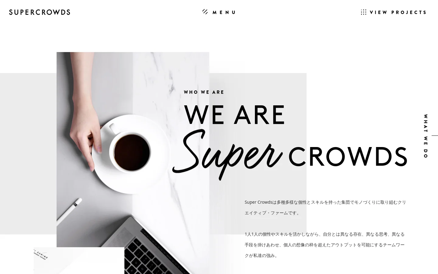 The desktop page features a minimalist white background with a large hero section containing a high-angle photograph of a hand next to a coffee cup and a laptop on a marble surface. Large, bold typography reads 'WHO WE ARE' and 'WE ARE Super CROWDS' overlapping the image, accompanied by Japanese text. A navigation menu is positioned at the top with links for 'MENU' and 'VIEW PROJECTS'.