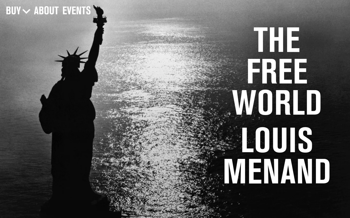 The desktop homepage features a large black and white hero image of the Statue of Liberty against a shimmering sea, with the book title 'THE FREE WORLD' and author 'LOUIS MENAND' in bold white typography. A navigation menu with 'BUY', 'ABOUT', and 'EVENTS' is positioned at the top left. The layout is expansive, using the full width of the screen to create a dramatic, cinematic effect.