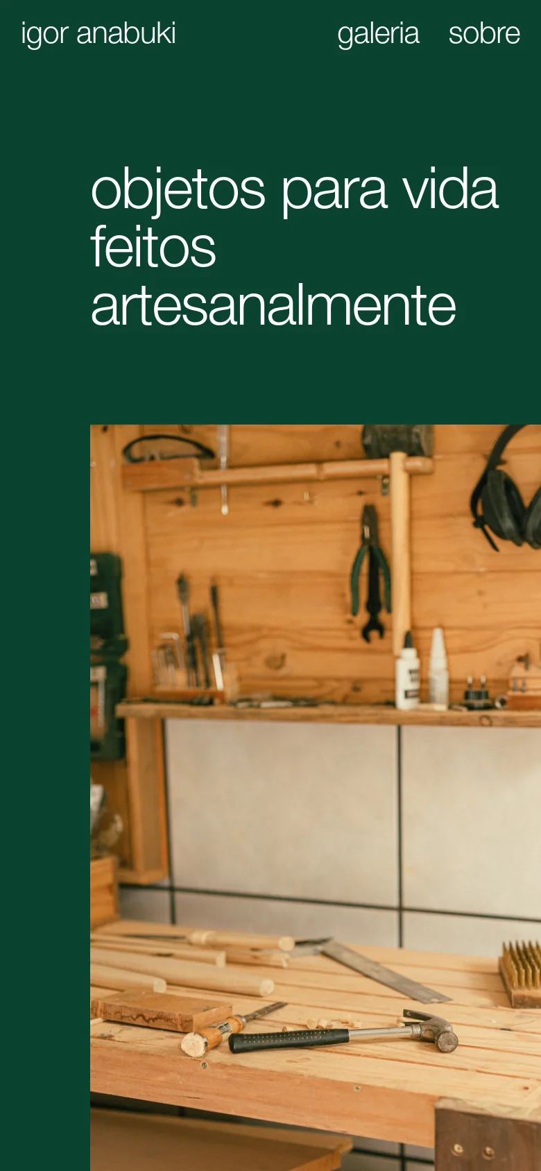 The mobile version maintains the dark green background and large white headline but uses a vertical layout. The text is centered above a large, vertically oriented photograph of a wooden workshop area filled with tools, occupying the bottom half of the screen.