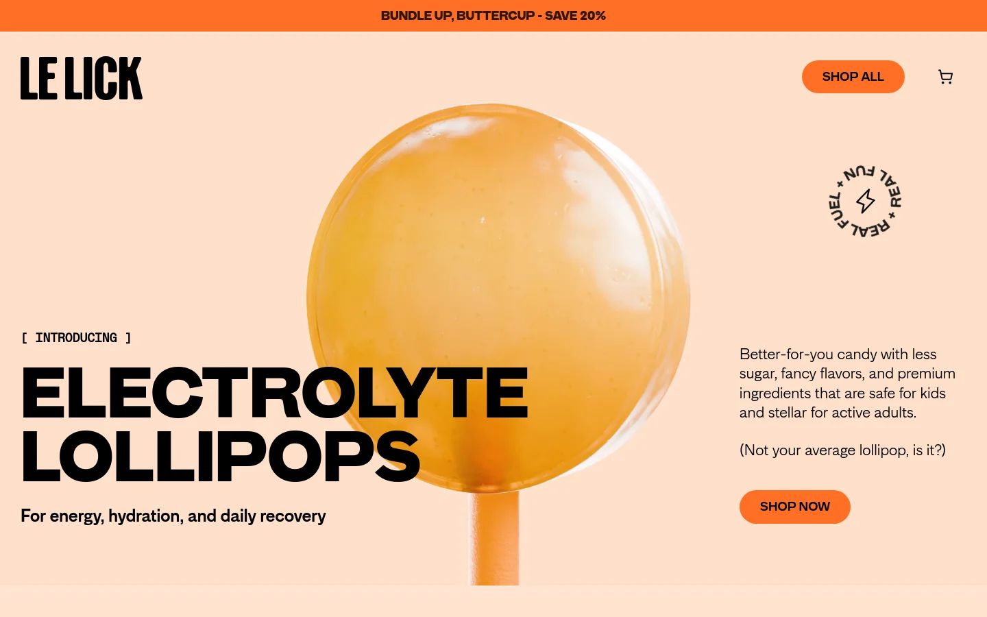 The desktop homepage features a minimalist peach background with a large, close-up hero image of an orange lollipop. The 'Le Lick' logo is in the top left, with a 'Shop All' button and shopping cart icon in the top right. Large, bold black text announces 'ELECTROLYTE LOLLIPOPS' alongside a 'Shop Now' call to action button.