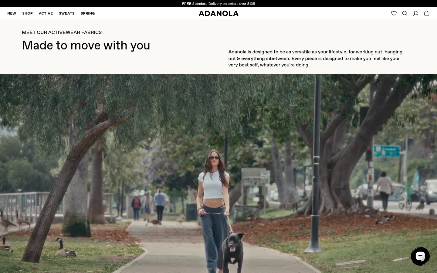 The desktop page features a clean, minimalist layout with a white header containing the Adanola logo and navigation links. A large hero section displays a wide cinematic image of a woman walking a dog in a park, accompanied by the headline 'Made to move with you' and introductory text. The color palette is neutral, focusing on natural tones from the photography.
