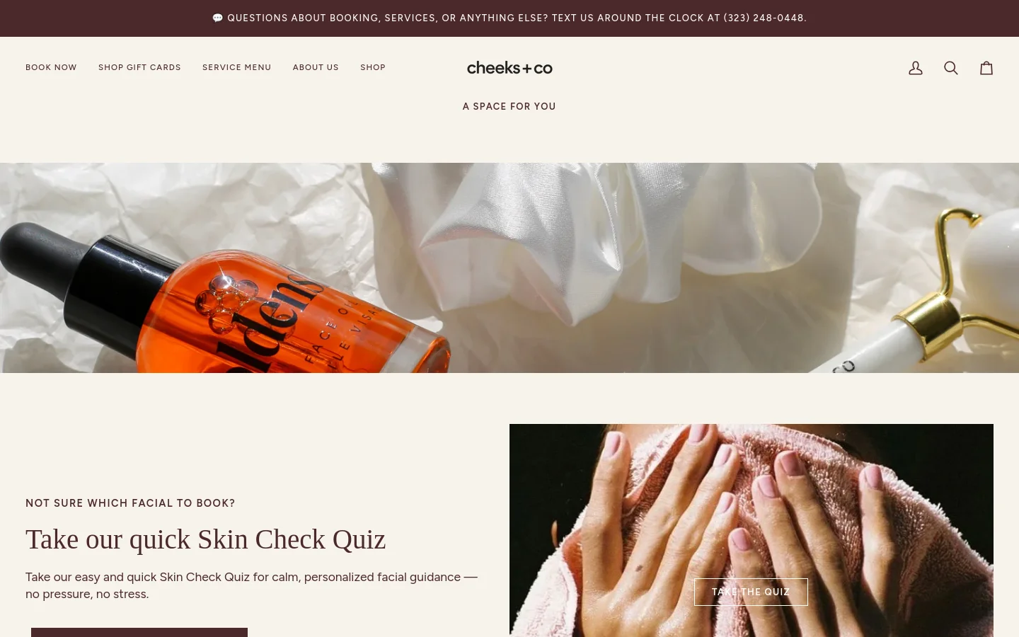 The desktop homepage features a clean, minimalist aesthetic with a neutral color palette. A wide hero image shows skincare products and a white scrunchie on textured white fabric, above which sits the headline 'Face the Elements' and a 'Shop Now' button. Below, sections include a Skin Check Quiz call-to-action with a person using a towel, a list of most-booked facials, and a product carousel for skincare items.