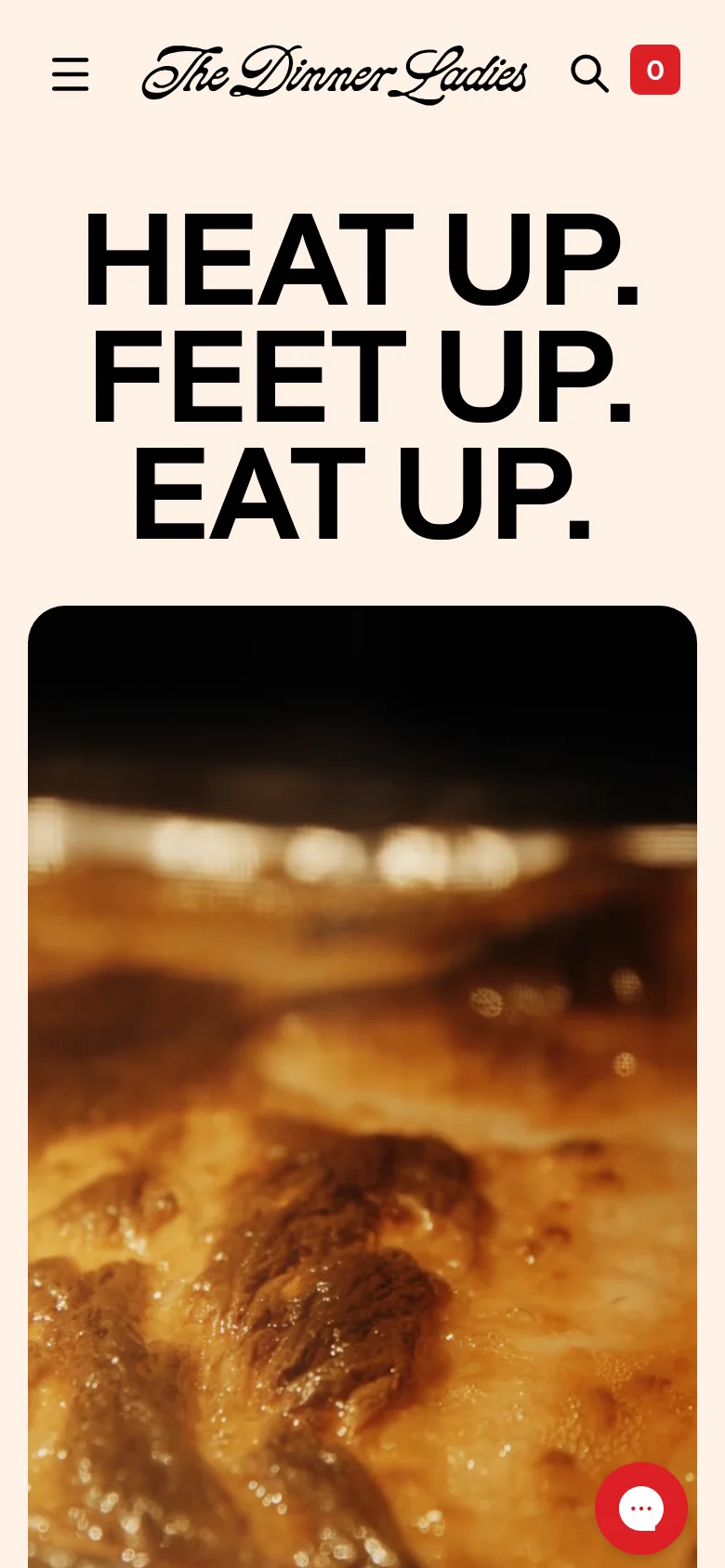 The mobile version simplifies the navigation into a hamburger menu icon alongside the logo and a search icon. The bold headline 'HEAT UP. FEET UP. EAT UP.' is centered and stacked vertically above a large, zoomed-in hero image of a golden-brown baked meal. A red floating chat button is visible in the bottom right corner.