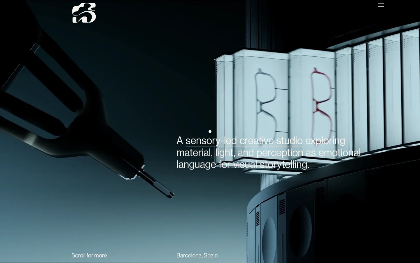 The desktop homepage for Spot Studio features a minimalist dark layout with a large, cinematic hero image of abstract, light-refracting objects. A white logo sits in the top left, a hamburger menu in the top right, and the central headline reads, 'A sensory-led creative studio exploring material, light, and perception as emotional language for visual storytelling.'