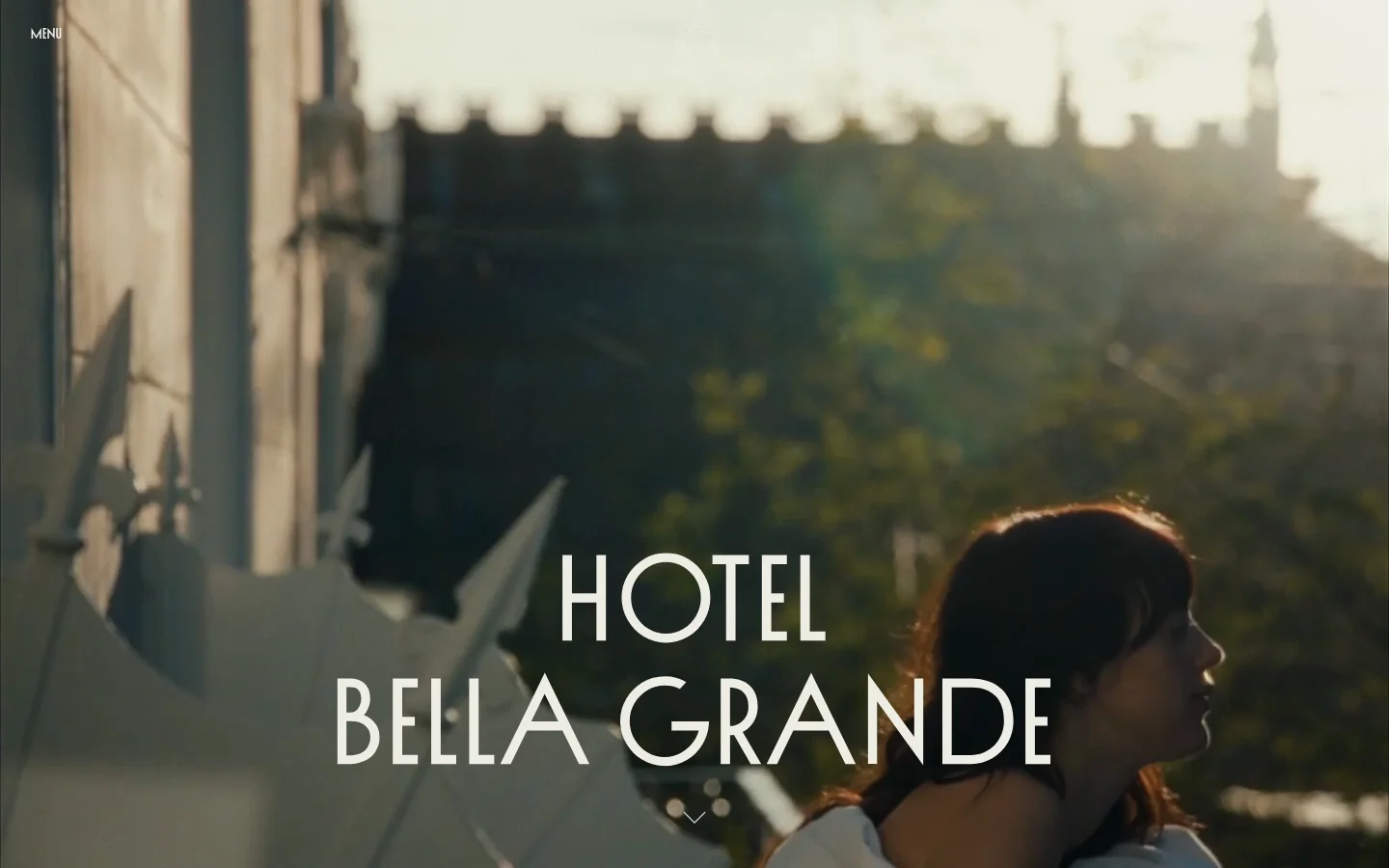 The desktop homepage features a large hero image of a person looking out over a cityscape with the text 'HOTEL BELLA GRANDE' centered. Below the hero, the layout includes a white background with elegant serif typography, sections for hotel descriptions, a gallery of high-quality interior photos, and call-to-action buttons for booking and exploring rooms. The color palette is sophisticated, utilizing warm tones from the photography and a clean white and dark text scheme.