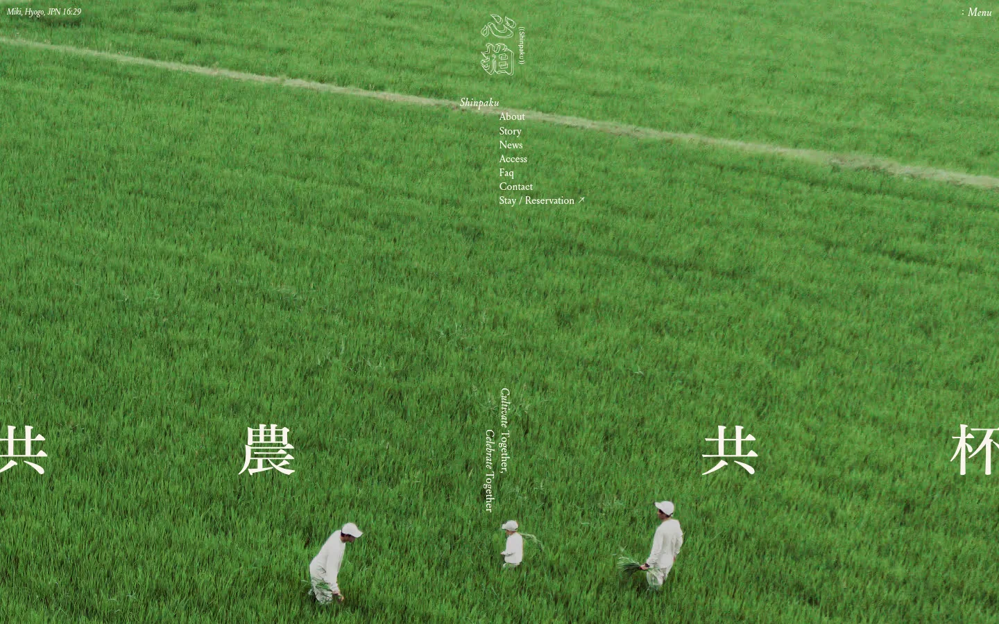 The desktop homepage features a full-width hero image of a lush green rice field with people working in the distance. A minimalist navigation menu is positioned on the right side, and large white Japanese calligraphy is overlaid across the center of the field. The layout is spacious and airy, using a natural green color palette to reflect the agricultural theme.