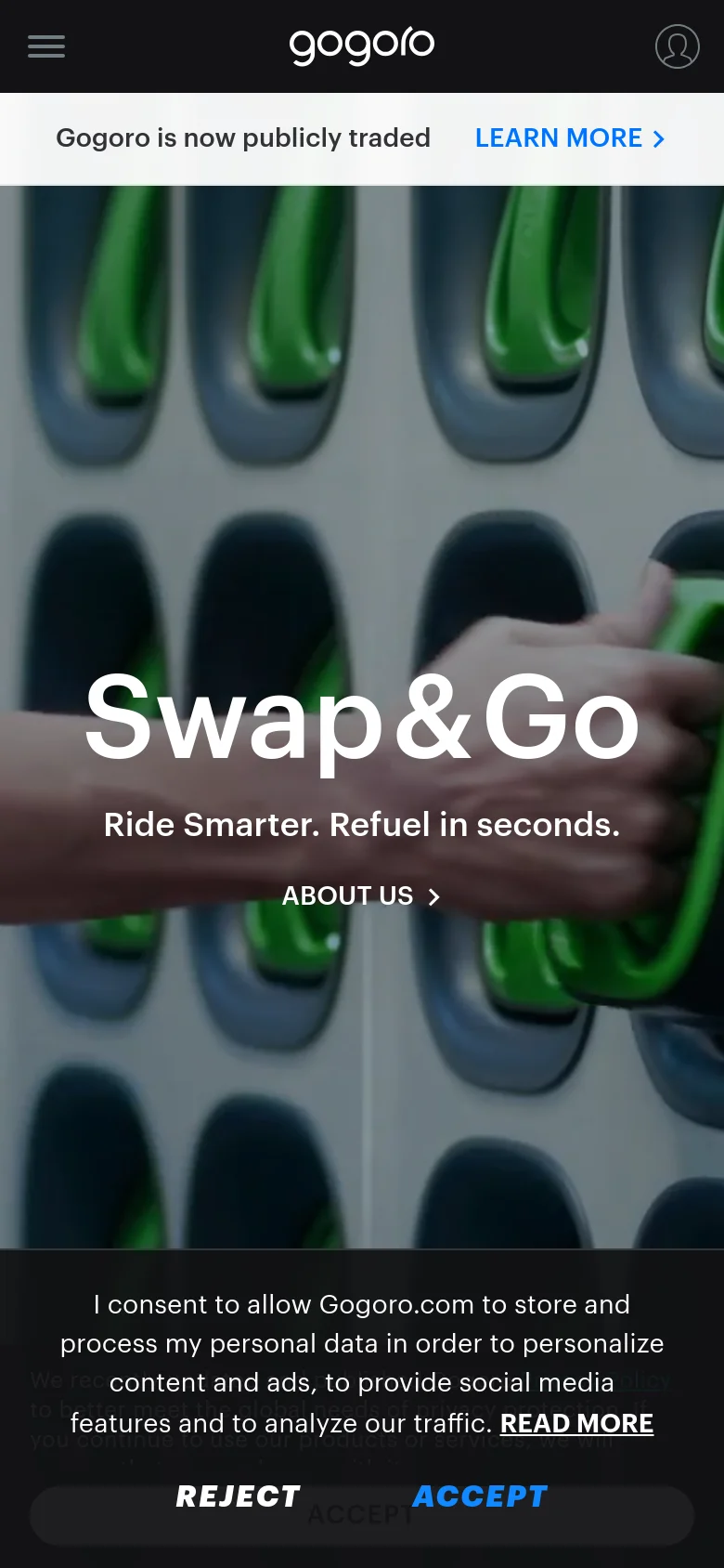 The mobile version uses a simplified layout with a hamburger menu and user icon in a dark header. The hero section remains centered with the 'Swap&Go' headline and 'ABOUT US' button over a blurred image of green battery handles. A cookie consent banner occupies the bottom of the screen with prominent 'REJECT' and 'ACCEPT' buttons.