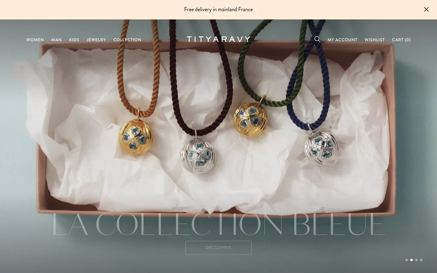 The desktop homepage features a minimalist design with a large hero image of several pendant necklaces resting on white tissue paper in a box. A centered headline reads 'LA COLLECTION BLEUE' above a 'DÉCOUVRIR' call-to-action button. The navigation menu is spread horizontally across the top, including links for Women, Man, Kids, Jewelry, and Collection.