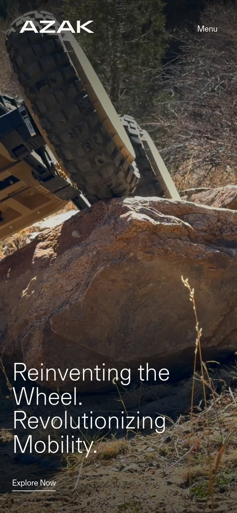 The mobile version presents a vertically oriented hero image of the wheel system on rocky terrain. The 'AZAK' logo and a 'Menu' button are at the top, while the main headline and an underlined 'Explore Now' link are prominently displayed at the bottom over the image.