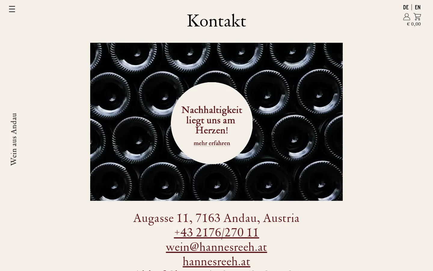The desktop contact page features a large hero image of dark wine bottle bottoms with a central white circle containing the text 'Nachhaltigkeit liegt uns am Herzen! mehr erfahren'. Below the image, the winery's address, phone number, email, and website are displayed in large, elegant serif typography against a light beige background. A vertical text element 'Wein aus Andau' runs along the left margin.