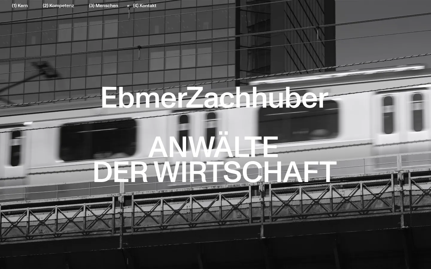 EbmerZachhuber homepage featuring a full-bleed grayscale hero image of a moving train against a modern glass building. Large white sans-serif typography reads EbmerZachhuber ANWÄLTE DER WIRTSCHAFT, set against a minimalist monochrome design with a simple top navigation menu.
