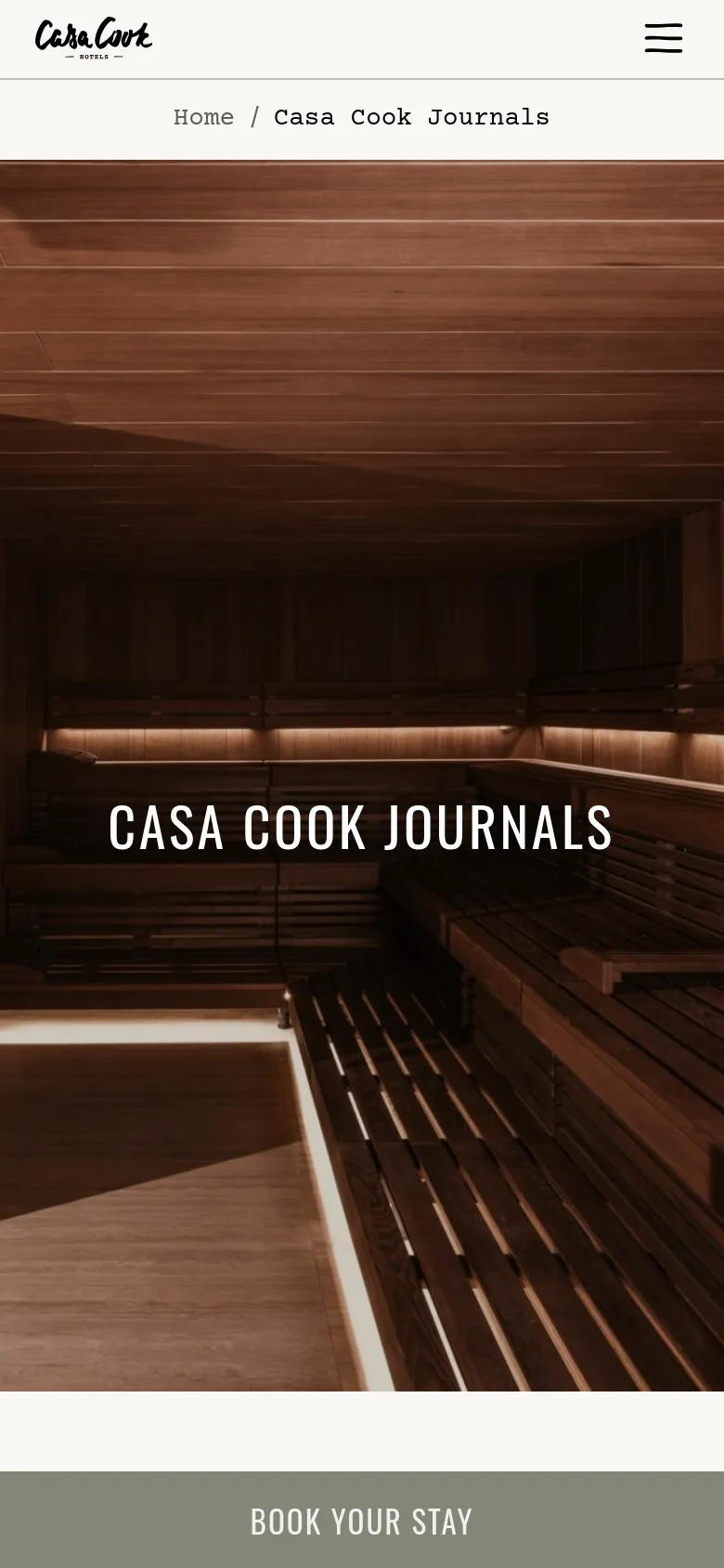 The mobile version presents a vertically oriented view of the wood-paneled sauna hero image. The 'CASA COOK JOURNALS' title remains centered, and the navigation is condensed into a hamburger menu icon on the left, with the brand logo centered at the top. The 'BOOK YOUR STAY' button is positioned as a full-width bar at the bottom of the screen.