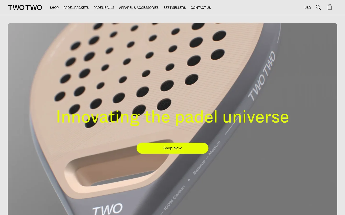 The desktop homepage features a large hero image of a close-up padel racket with the headline 'Innovating the padel universe' in bright yellow text and a yellow 'Shop Now' button. A clean white navigation bar at the top includes the TWOTWO logo, links for Shop, Padel Rackets, Padel Balls, Apparel & Accessories, Best Sellers, and Contact Us, alongside a search icon and shopping bag. The layout is minimalist with a focus on high-quality product imagery and ample white space.