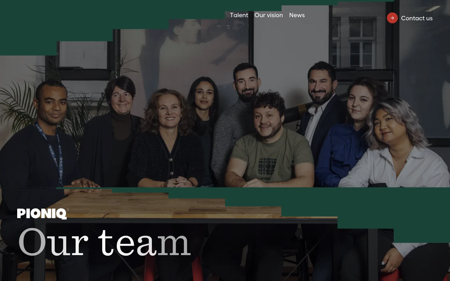 The desktop page features a large hero image of the Pioniq team sitting around a wooden table, overlaid with a dark green geometric shape and the white headline 'Our team'. The navigation menu is at the top right, including links for Talent, Our vision, News, and a 'Contact us' button. The layout uses a clean, professional design with high-contrast white typography against dark and photographic backgrounds.