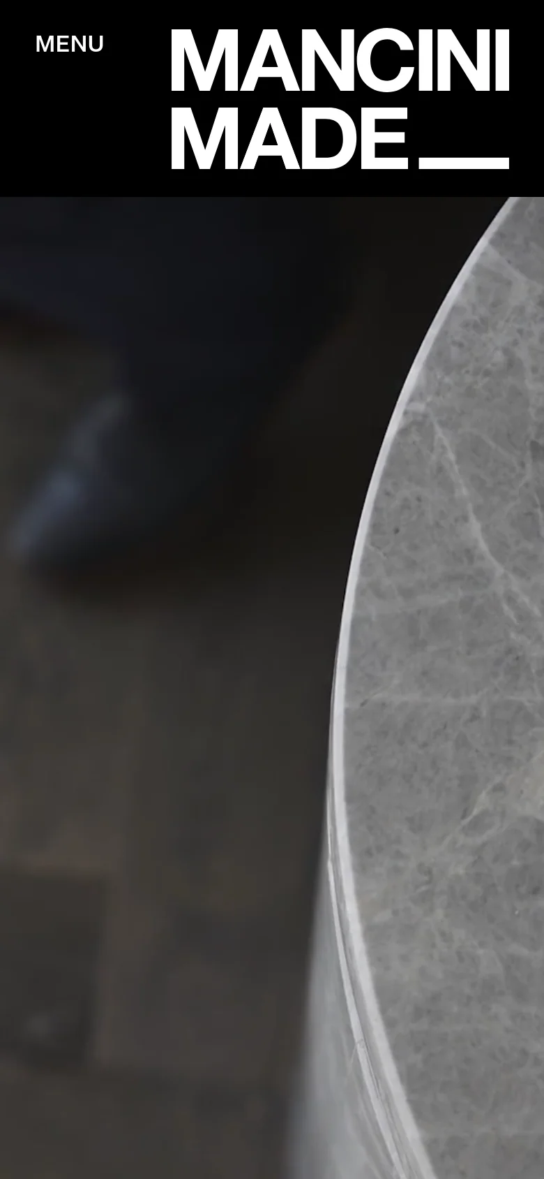 The mobile version uses a stacked layout with a prominent 'MANCINI MADE' logo and a 'MENU' button at the top. The hero image is cropped to show a close-up detail of a marble surface, and the text is centered to fit the narrow screen width.