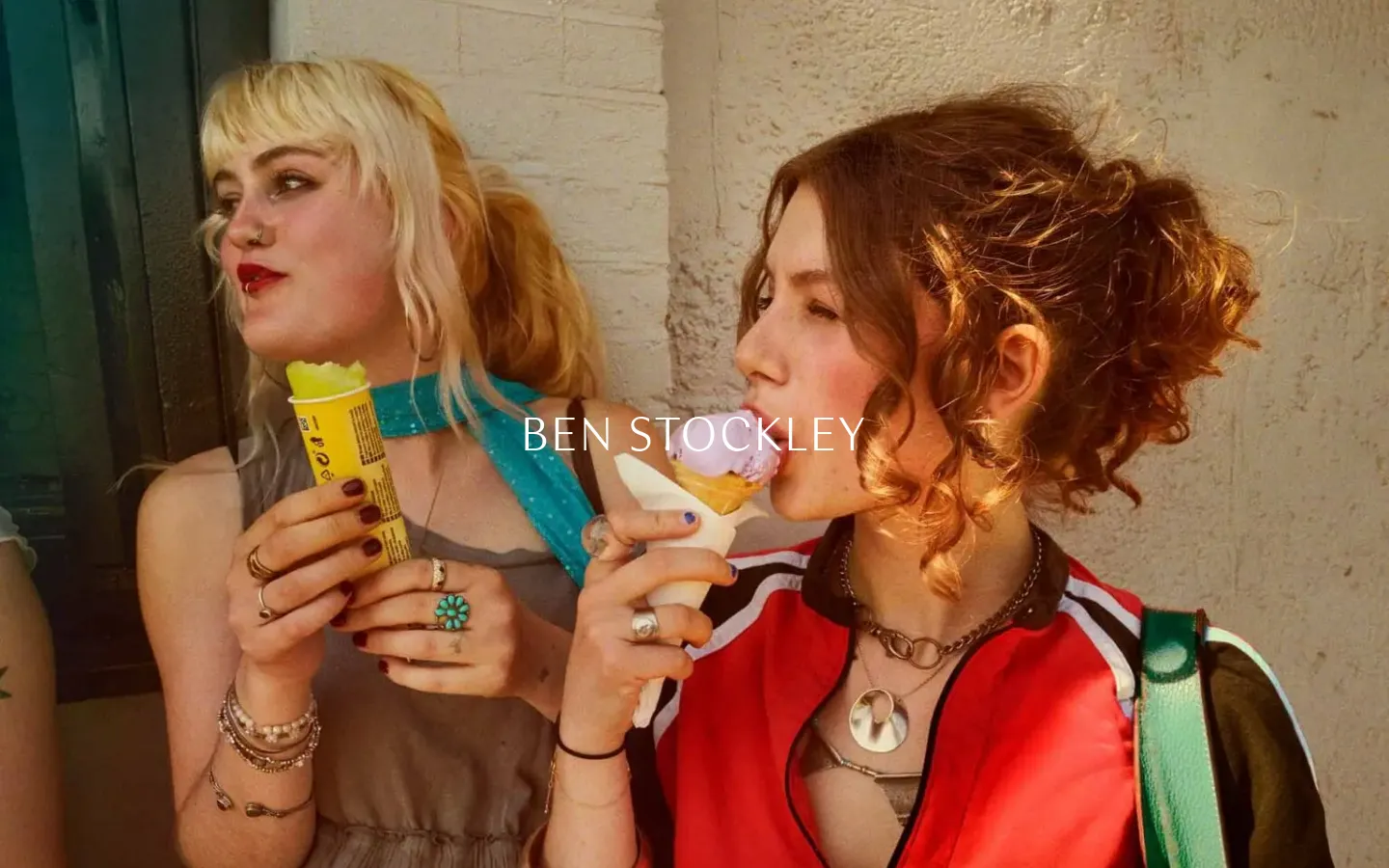 The desktop landing page features a large, cinematic hero photograph of two young women eating ice cream against a textured wall. The name 'BEN STOCKLEY' is centered in white sans-serif text over the image, with a minimalist navigation menu and project links visible below.