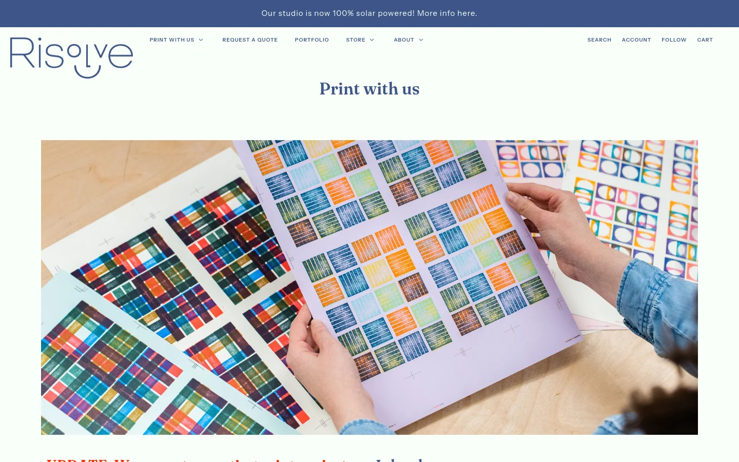 The desktop page features a clean white background with a blue announcement banner at the top. A large hero image shows hands holding colorful Risograph print samples over a wooden surface, followed by the headline 'Print with us' and an urgent red update notice stating they are not currently accepting projects.