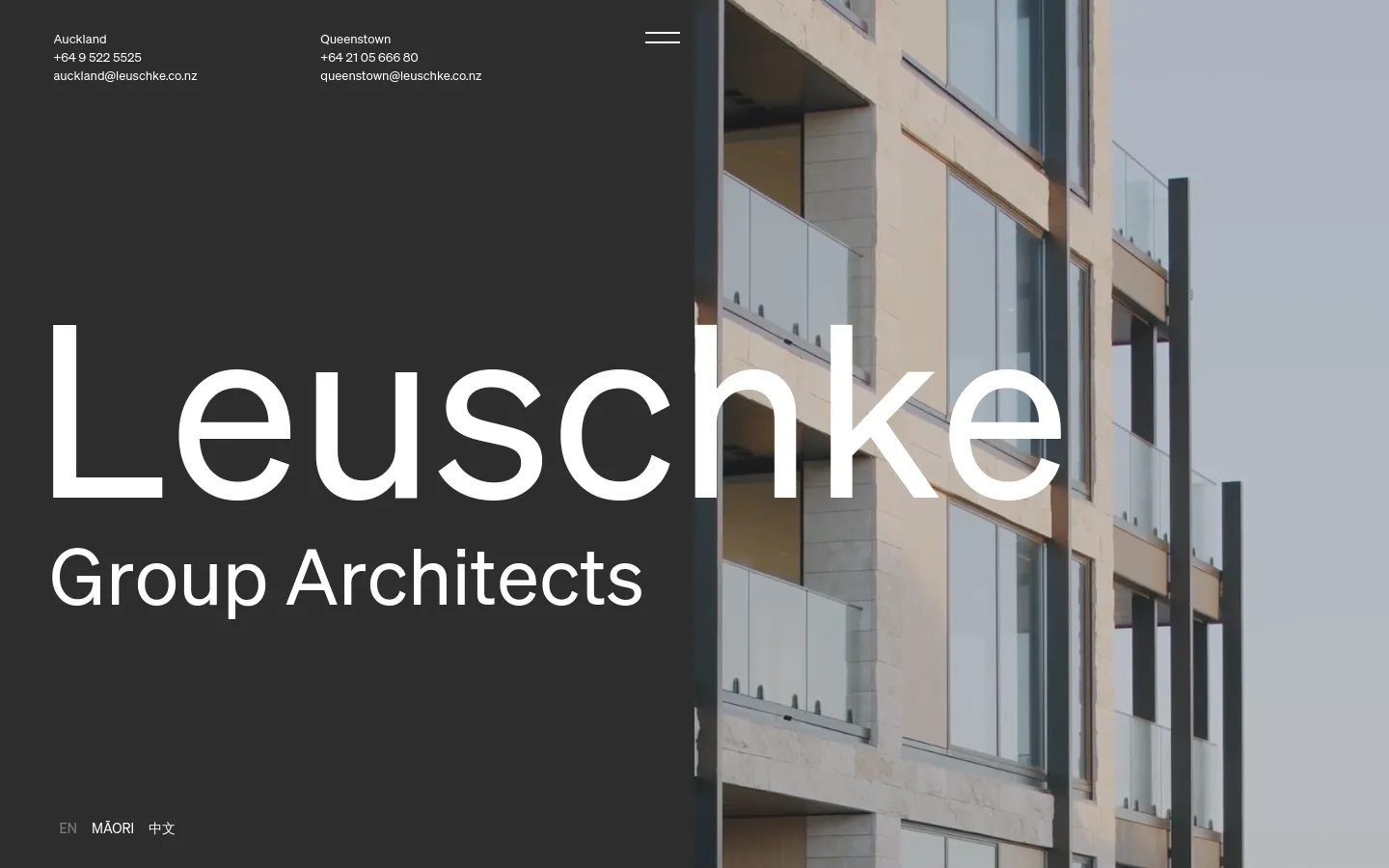 The desktop homepage features a split-screen hero section with a dark grey left panel containing the large white text 'Leuschke Group Architects' and contact details for Auckland and Queenstown. The right panel shows a high-angle architectural photograph of a modern building with large glass windows. A minimalist navigation menu is visible at the top.