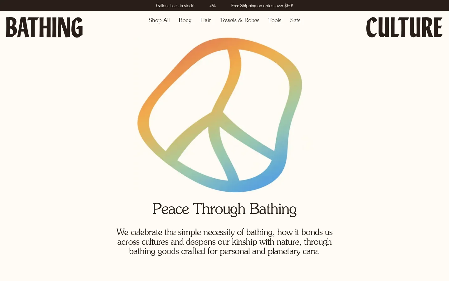 The desktop page features a minimalist design with a large, centered peace sign graphic in soft orange, yellow, and blue gradients. The brand name 'BATHING CULTURE' is split on either side of a top navigation menu, and the headline 'Peace Through Bathing' sits below the icon above a short paragraph of text. The background is a clean, off-white color.