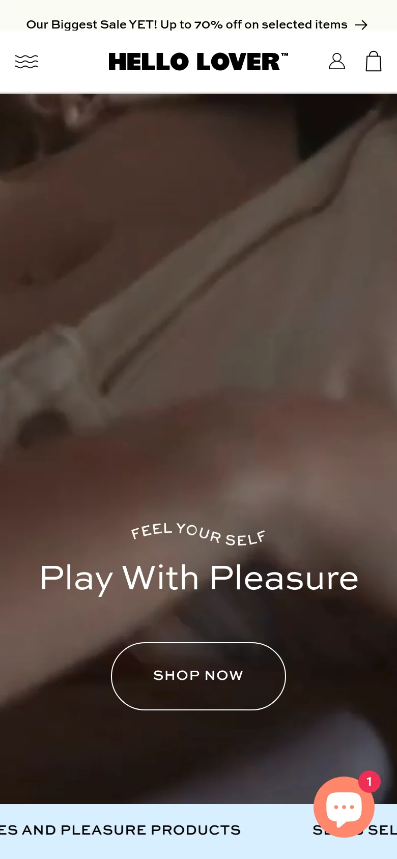 The mobile version presents a vertically oriented hero section with the same warm-toned imagery and 'Play With Pleasure' headline and 'SHOP NOW' button. The header is simplified, showing a menu icon, the 'HELLO LOVER' logo, a user icon, and a shopping bag, while the announcement bar remains at the top. A floating chat bubble icon with a notification badge appears in the bottom right corner.