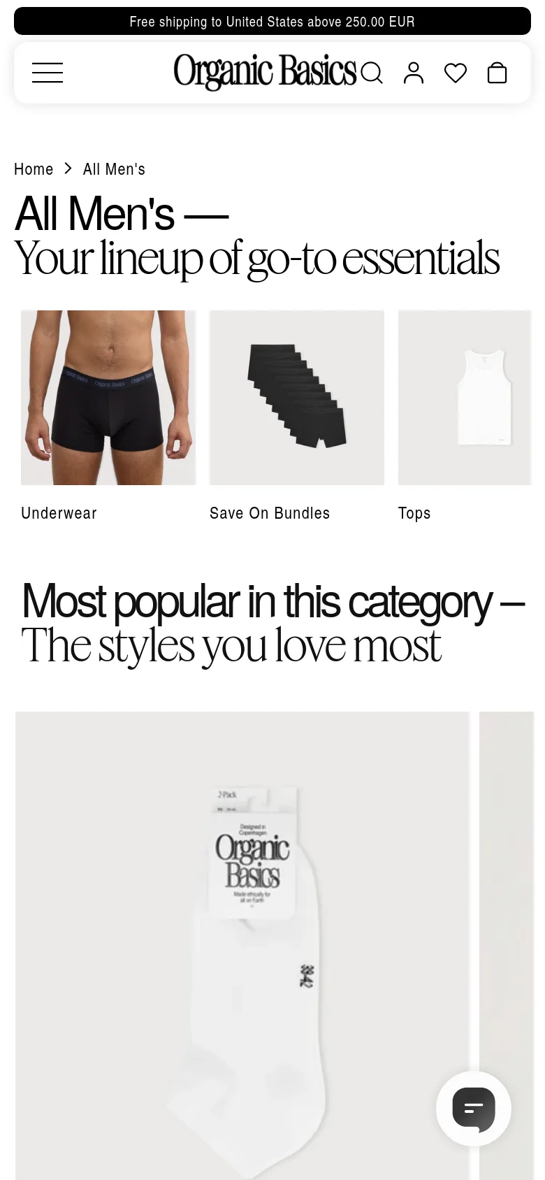The mobile version presents a single-column vertical layout with the same large 'All Men's' headline. The category navigation is displayed as large, stacked image tiles for Underwear, Save On Bundles, and Tops, followed by a 'Most popular in this category' section. The header is condensed, showing the Organic Basics logo, a search icon, a profile icon, a heart icon, and a shopping bag icon.