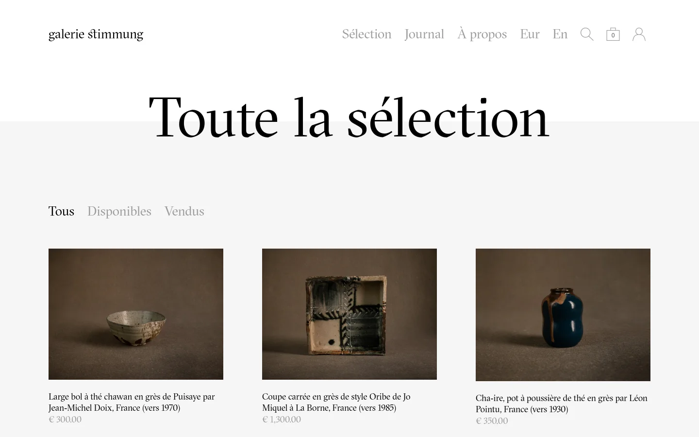 The desktop version of the 'Toute la sélection' page features a minimalist white layout with a centered headline and navigation links for 'Tous', 'Disponibles', and 'Vendus'. A grid of ceramic artworks is displayed, each with a high-quality photograph, a descriptive title in French, and a price. The header includes the gallery name, main menu links, language/currency selectors, a search icon, a shopping bag, and a user profile icon.