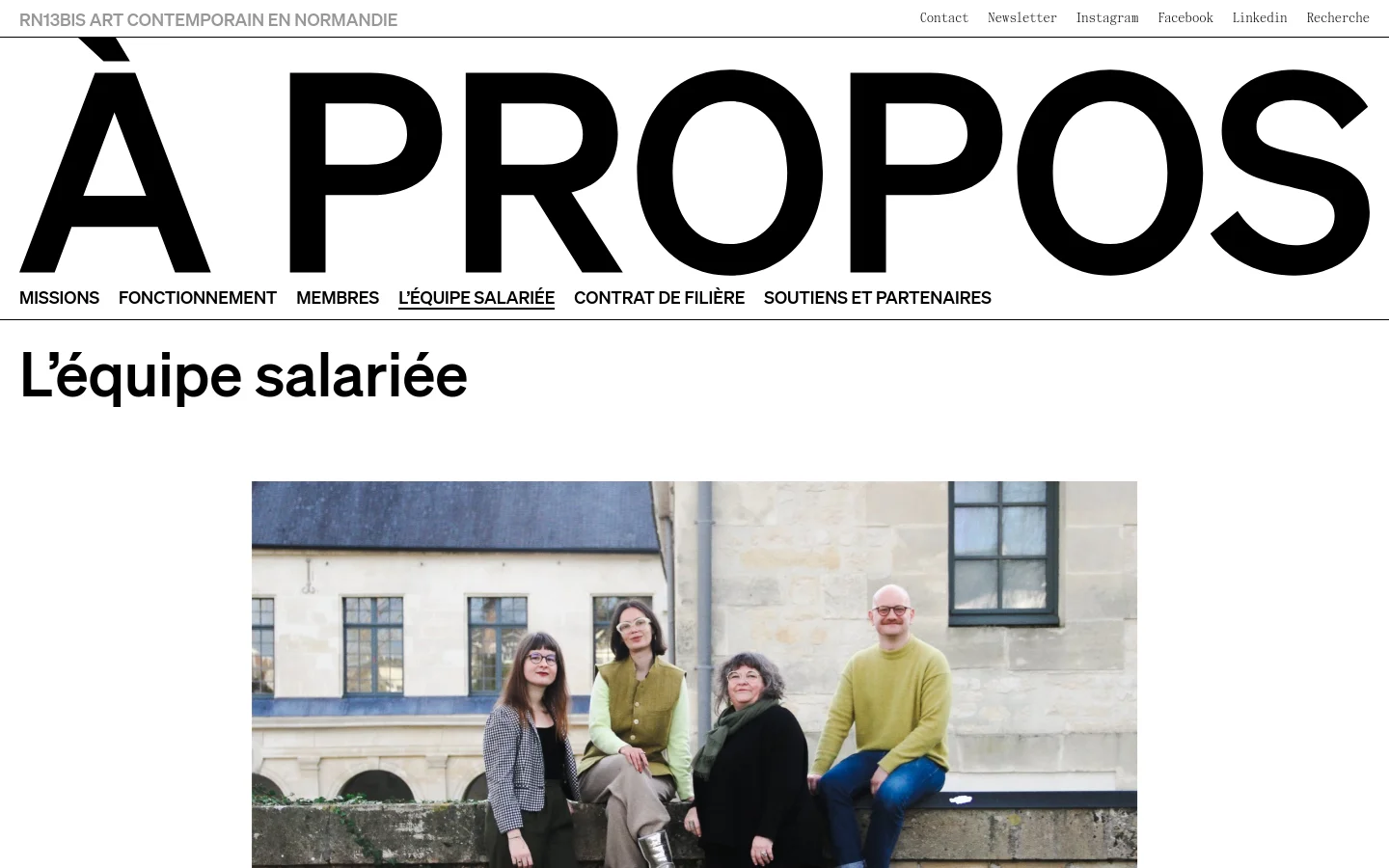 The desktop page features a minimalist design with a large 'À PROPOS' header and a navigation menu below it. A large group photo shows four staff members sitting outdoors in front of a stone building, followed by a list of team members with their roles, names, emails, and phone numbers.