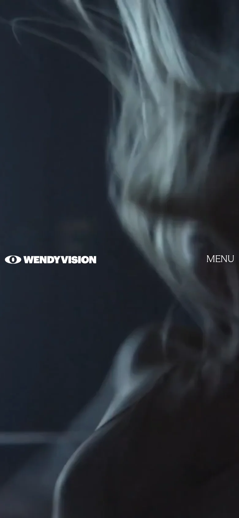 The mobile version displays a vertically oriented, close-up cinematic shot of a person's face in soft focus with a dark, moody aesthetic. The WENDYVISION logo is positioned on the left and a 'MENU' button is on the right, both in white text against the dark background.