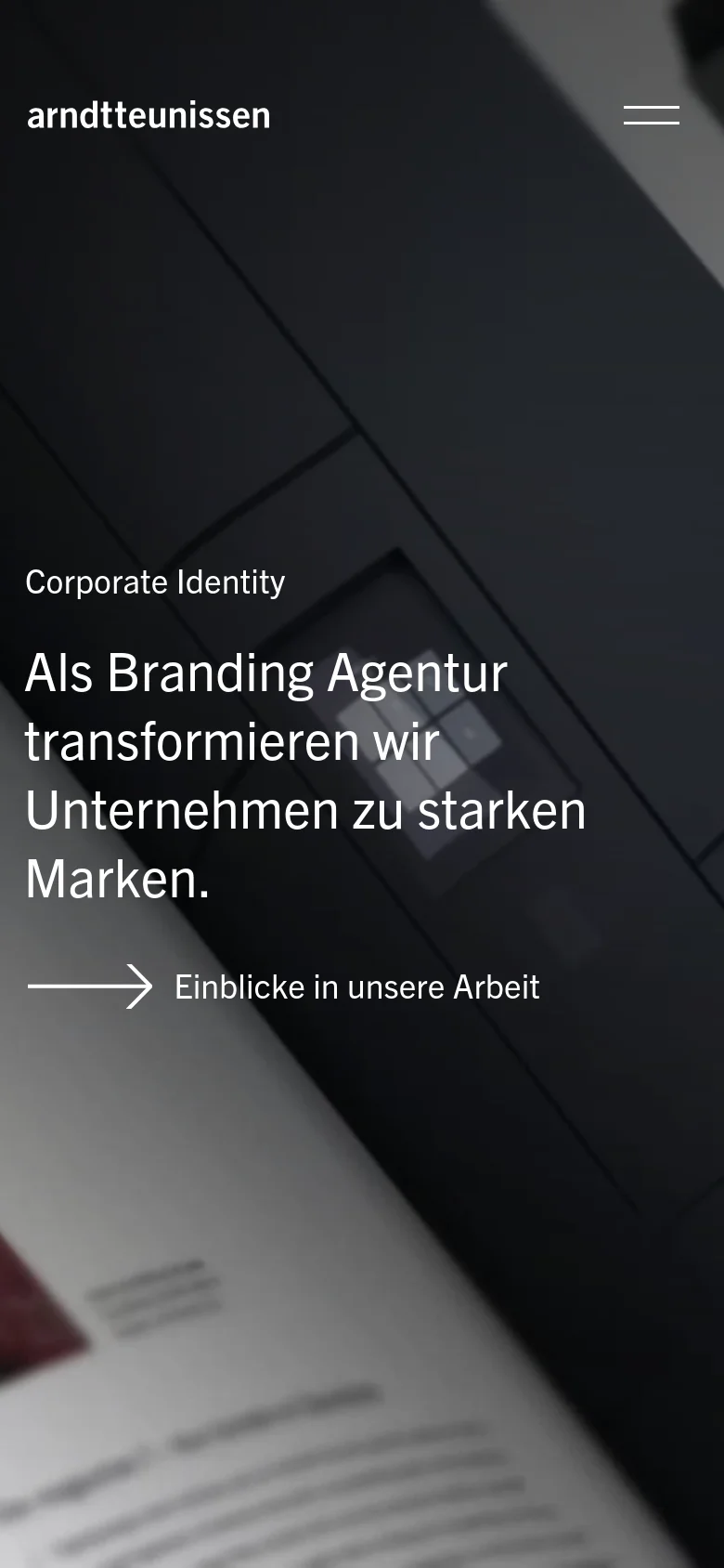 The mobile version simplifies the layout, featuring a condensed hero section with the same headline and white text over a dark, blurred background image. The top navigation is replaced by a hamburger menu icon on the right, and the 'Einblicke in unsere Arbeit' call-to-action is prominently centered with a large white arrow.