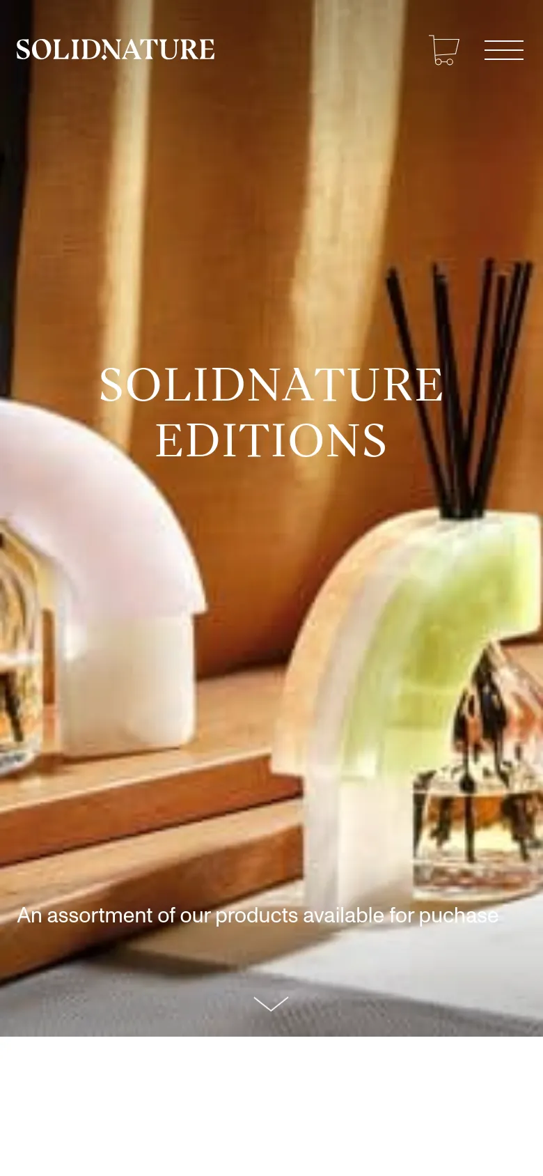 The mobile version presents a vertically oriented hero image of the stone fragrance products, with the 'SOLIDNATURE EDITIONS' headline centered in large white text. The navigation is simplified to a hamburger menu and a shopping cart icon at the top, and the layout is optimized for a single-column scroll.