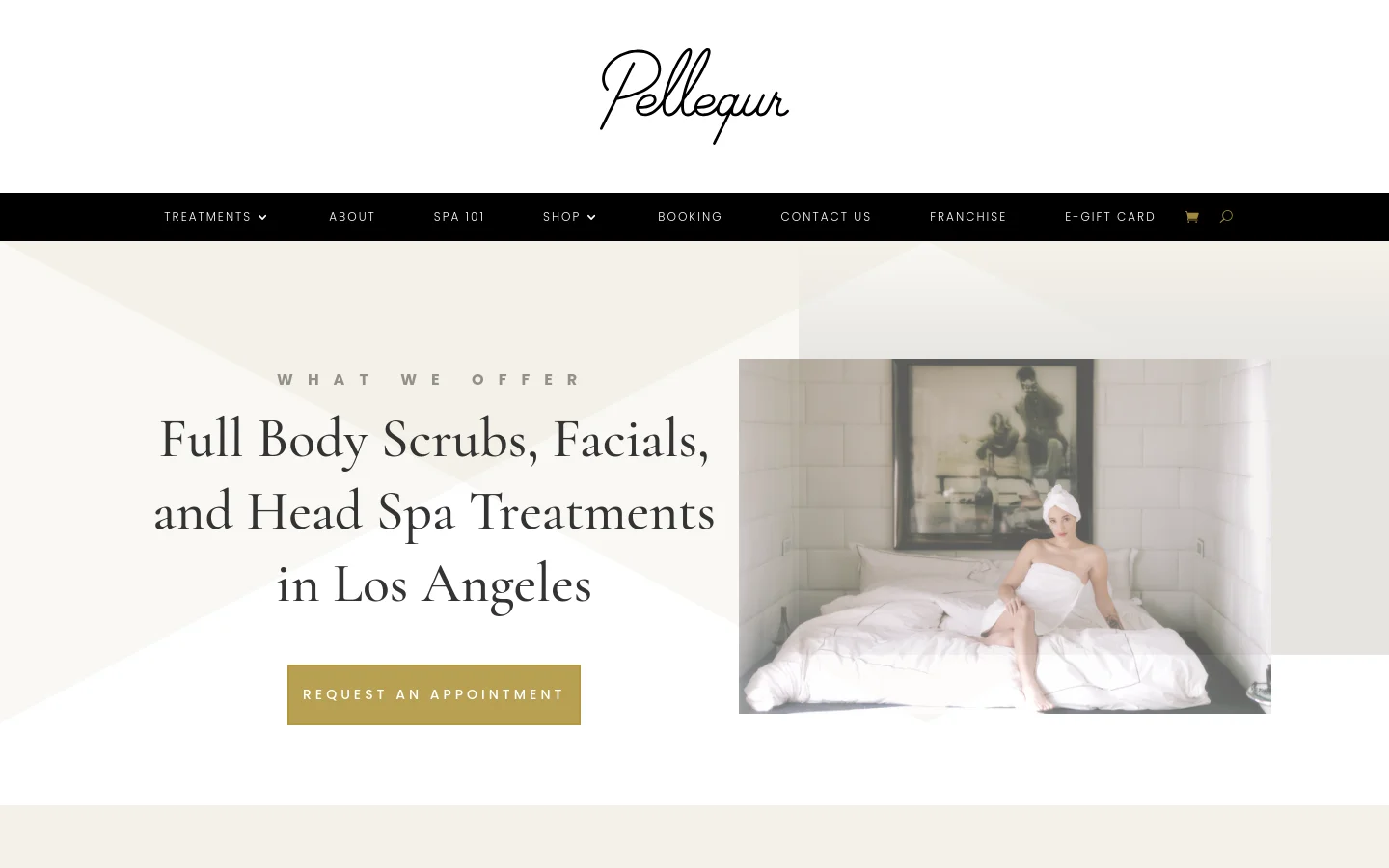 The desktop page features a minimalist white and beige design with a large hero section containing the headline 'Full Body Scrubs, Facials, and Head Spa Treatments in Los Angeles' and a gold 'Request an Appointment' button. To the right is a large photo of a woman in a white robe sitting on a spa bed. A black navigation bar at the top includes links for Treatments, About, Spa 101, Shop, Booking, Contact Us, Franchise, and E-Gift Card.