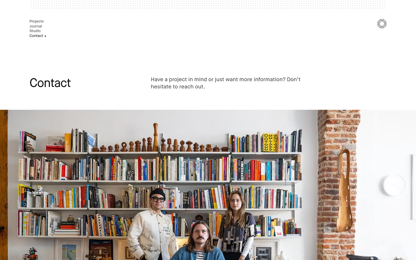 The desktop Contact page features a minimalist white layout with a navigation menu on the top left and a logo on the top right. A large hero image shows three people sitting in front of a tall, white bookshelf filled with books and wooden objects in a bright studio. Below the image, contact information is organized into sections for New Business, General, Jobs, Press, and Newsletter.