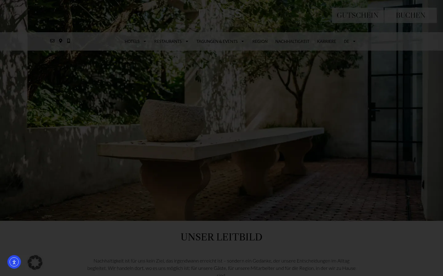 The desktop page features a large hero image of a stone bench and planter in a sunlit courtyard, overlaid with a navigation menu and 'GUTSCHEIN' and 'BUCHEN' buttons. Below the hero section, the 'UNSER LEITBILD' headline introduces text content about sustainability organized into sections like Environment, Social Responsibility, and Region. The design uses a sophisticated palette of earthy tones, dark greens, and cream.