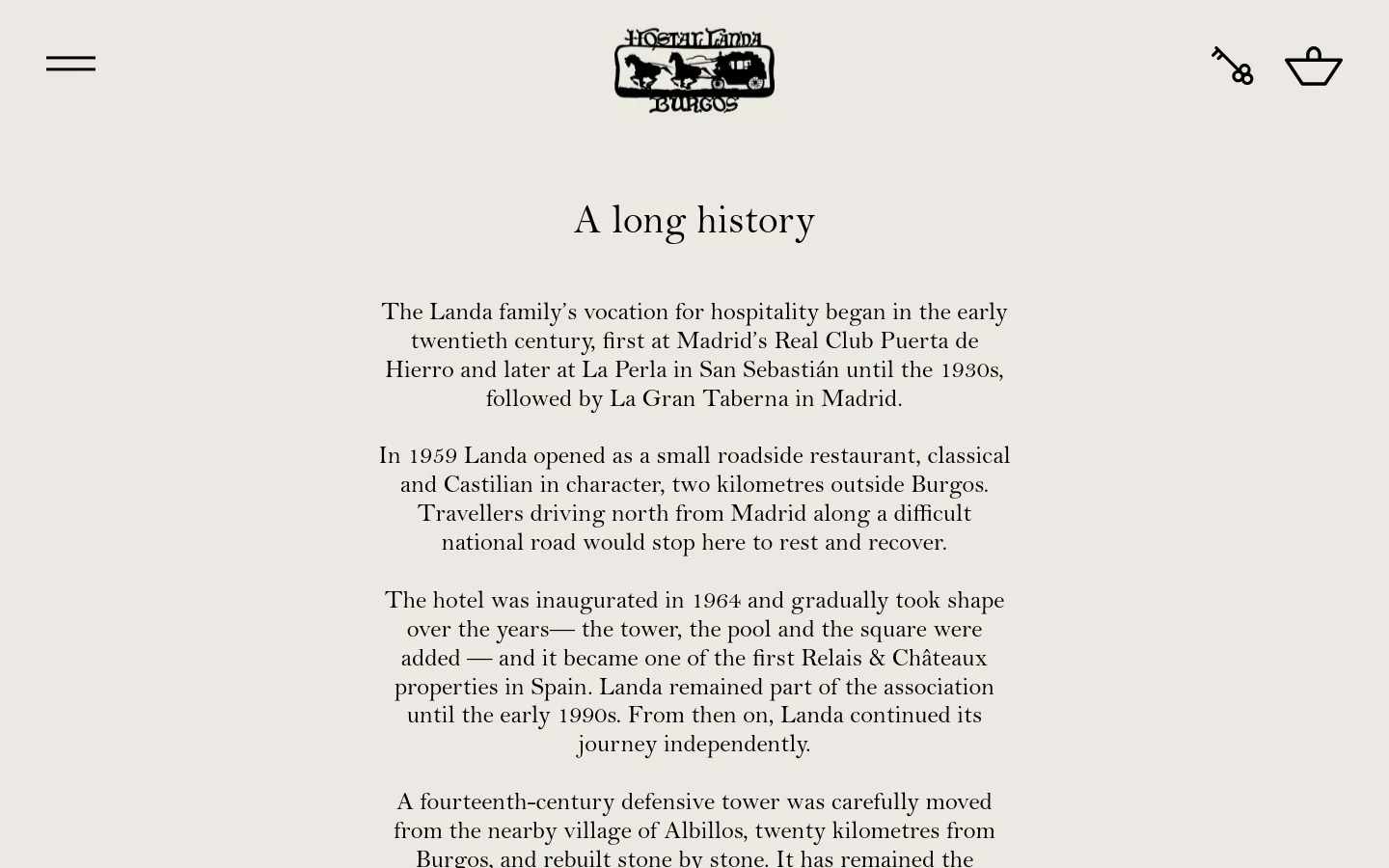 The desktop homepage features a minimalist design with a light beige background and black serif typography. A central logo of a horse and carriage sits above the headline 'A long history,' followed by several paragraphs of text detailing the family's heritage. Navigation includes a hamburger menu on the left and icons for a key and shopping bag on the right.