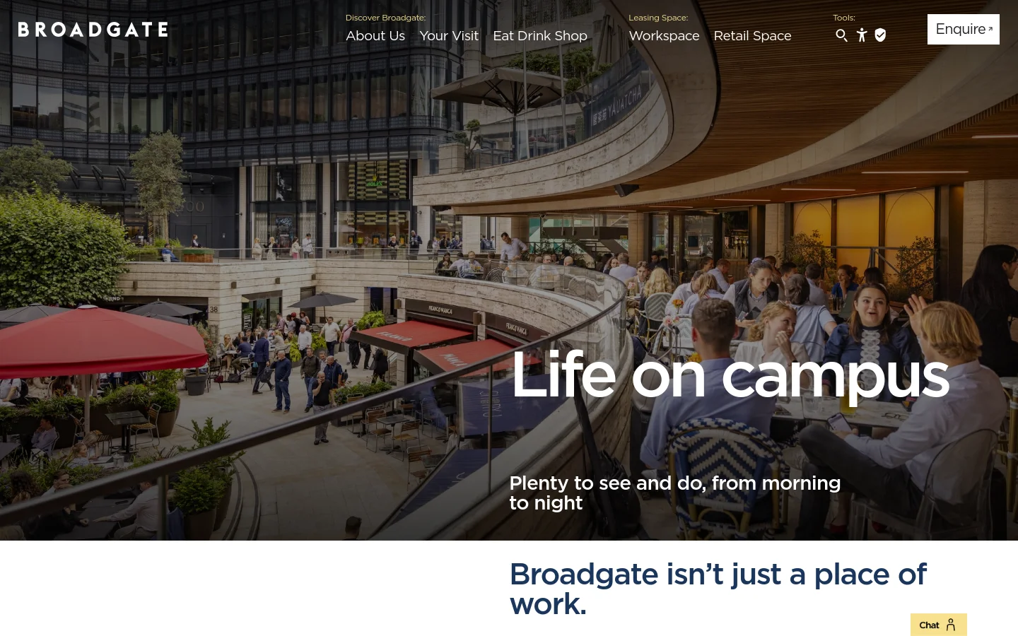 The desktop About Us page features a large hero image of a bustling outdoor plaza with people dining at tables under red umbrellas. The headline 'Life on campus' is displayed in large white text over the image, with a navigation menu at the top containing links for About Us, Your Visit, Eat Drink Shop, Workspace, and Retail Space. The color palette is natural with stone, glass, and greenery, accented by the dark Broadgate logo.