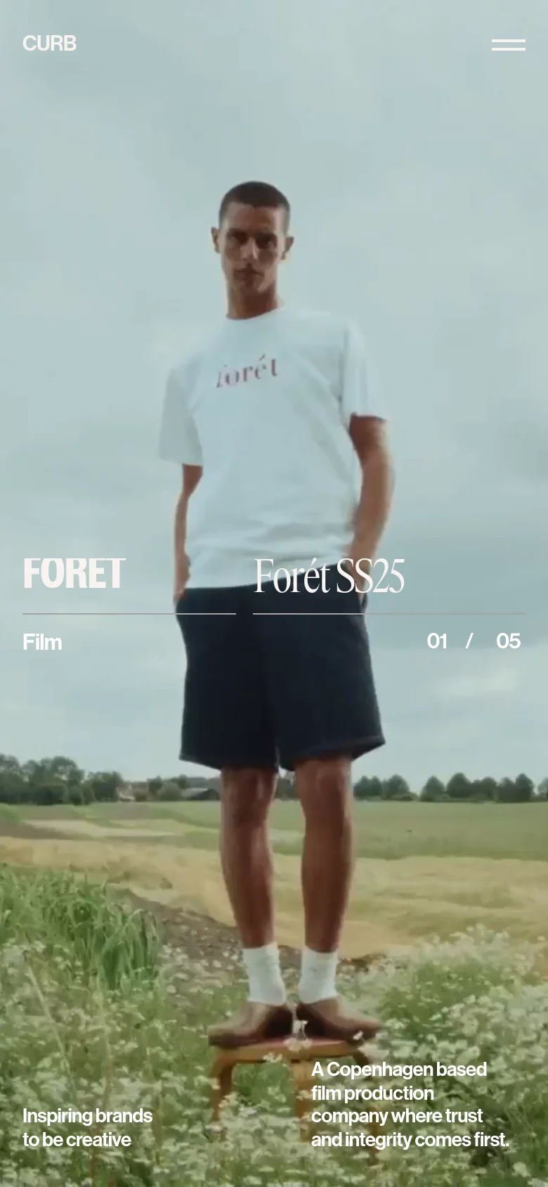 The mobile version presents a vertically oriented version of the hero image featuring the same man in a white shirt. The navigation is condensed into a hamburger menu icon in the top right, and the text elements, including the company tagline and project title, are repositioned to fit the narrow screen width.