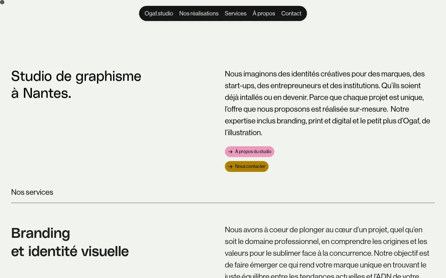 Desktop view of the Services page featuring a minimalist design with a light grey background. The hero section contains a large headline 'Studio de graphisme à Nantes' on the left, a descriptive paragraph on the right, and two rounded call-to-action buttons in pink and gold. A black pill-shaped navigation bar is centered at the top.