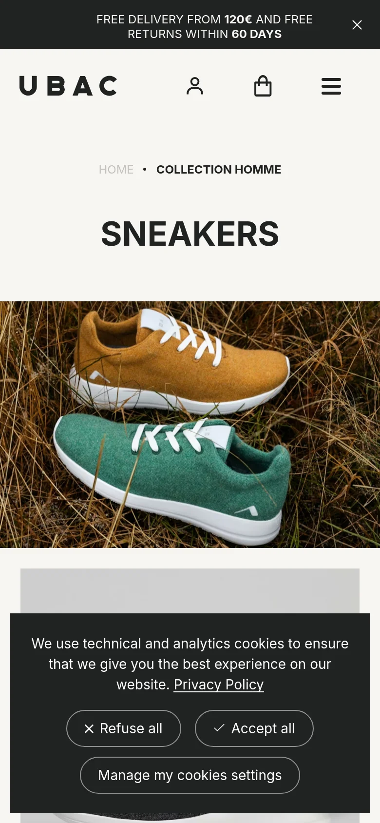 The mobile version features a centered layout with a stacked design. The 'SNEAKERS' headline is prominent above a full-width hero image of two sneakers in grass. Navigation is condensed into a hamburger menu, and a cookie consent banner overlays the bottom of the screen.