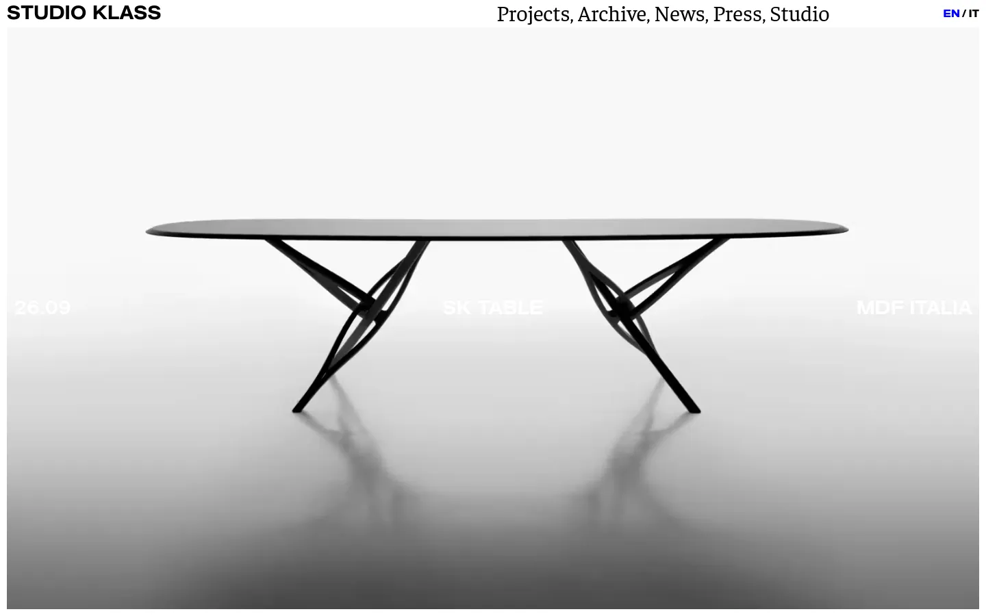 The Studio Klass homepage features a minimalist white layout with a large hero image of a black SK Table with sculptural legs. A top navigation bar includes the studio name on the left and links for Projects, Archive, News, Press, and Studio on the right. Below the hero section, a grid of large project images showcases various design works with text overlays.