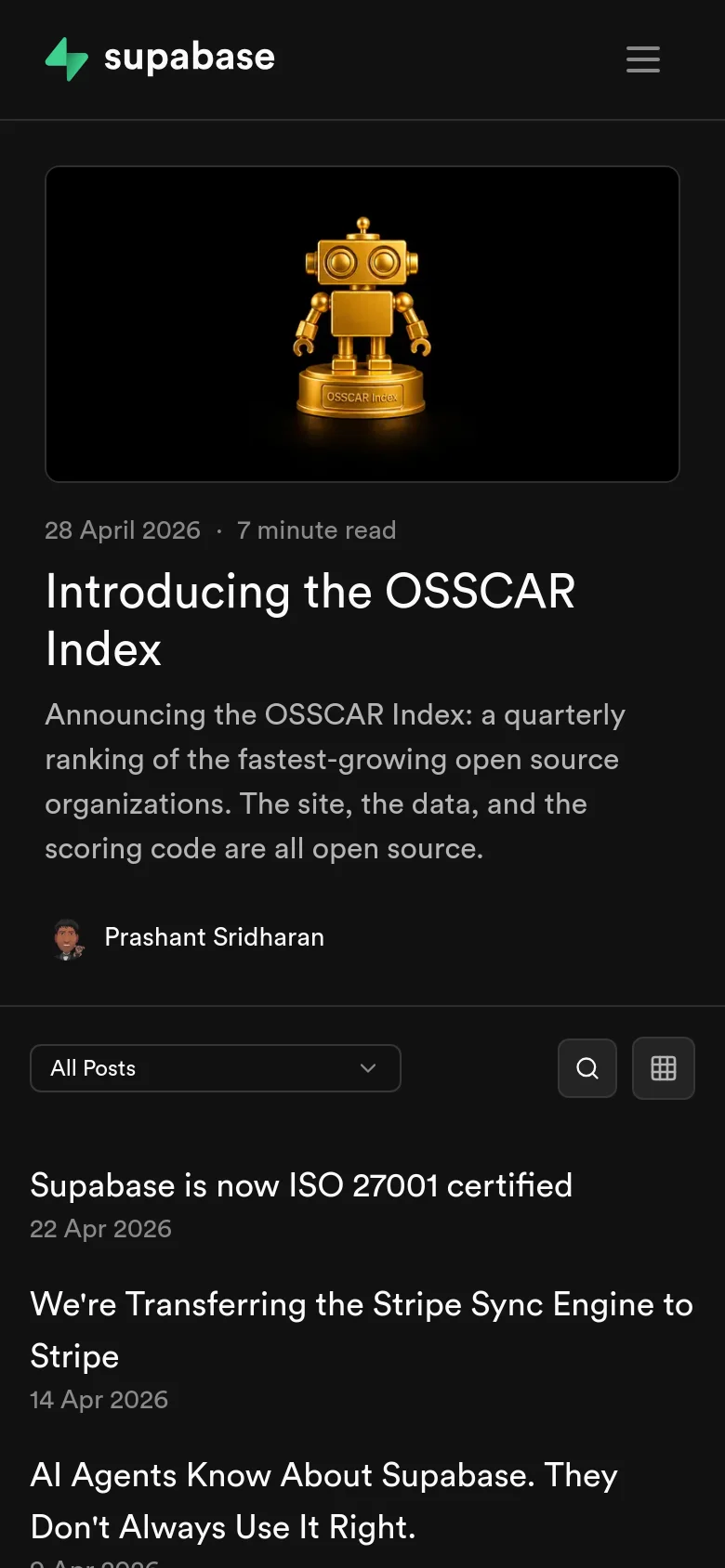 The mobile version maintains the dark aesthetic but presents a more condensed layout. The hero section with the golden robot and main headline is stacked vertically, followed by a simplified 'All Posts' dropdown menu instead of the horizontal filter bar. The blog post list is streamlined for vertical scrolling on a smaller screen.