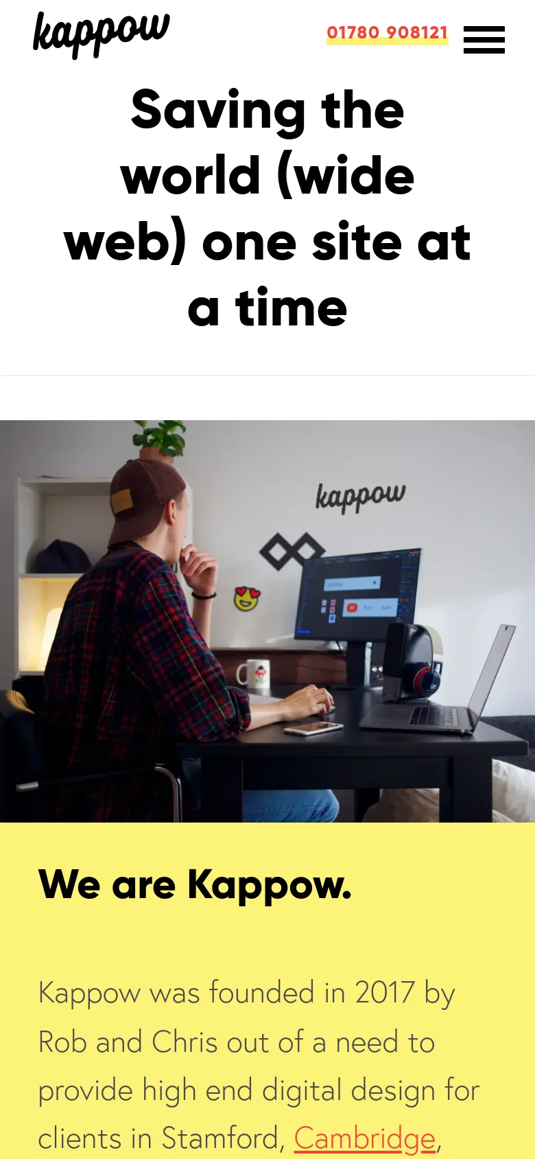 The mobile version presents a simplified layout with the Kappow logo, a phone number, and a hamburger menu icon in the header. The hero section features the headline 'Saving the world (wide web) one site at a time' in large, centered black text. Below the headline, a full-width photograph shows a person working at a desk with computers.