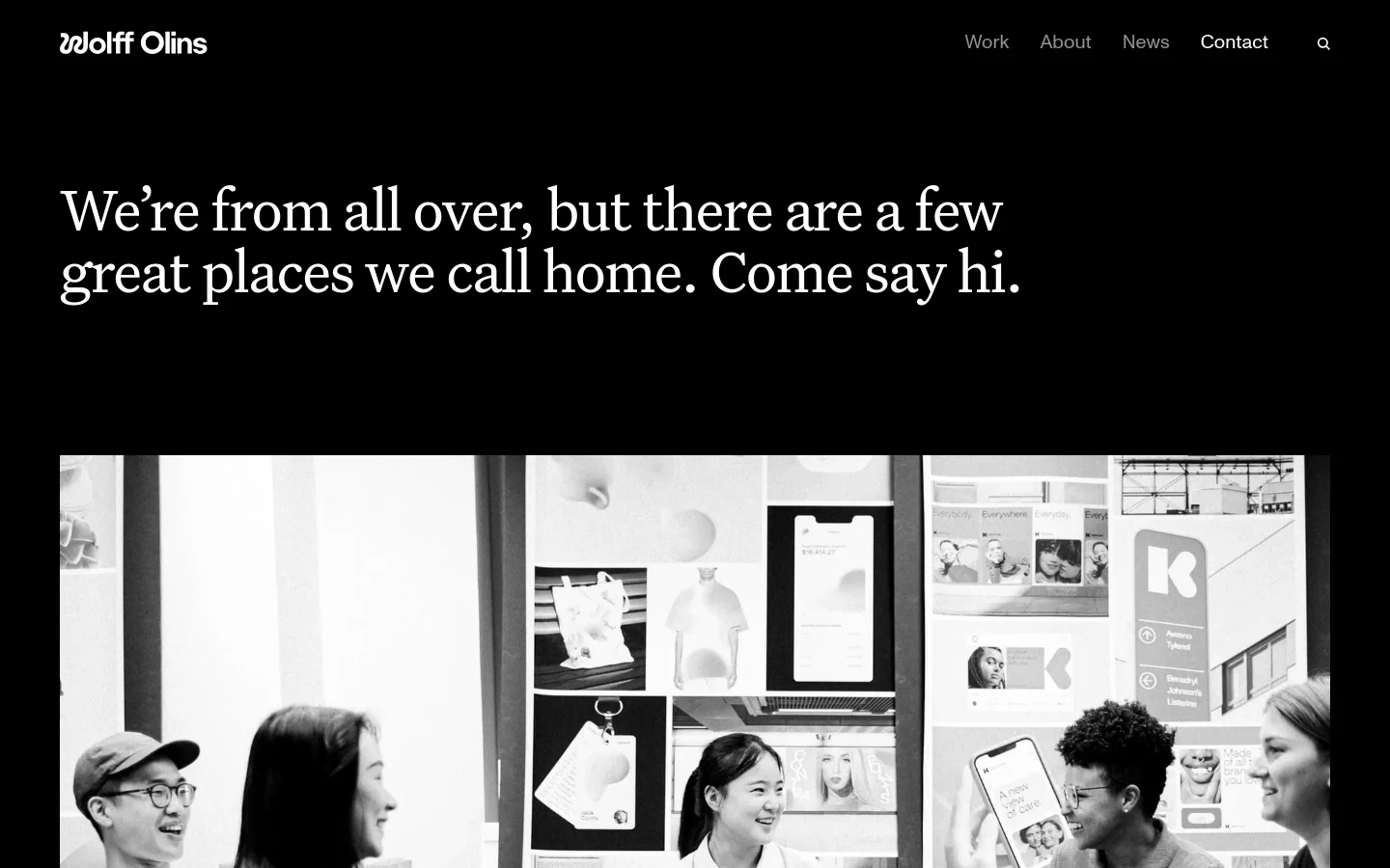 The Contact page features a minimalist black background with large white serif text reading, 'We’re from all over, but there are a few great places we call home. Come say hi.' Below the headline is a large, black-and-white photographic collage of people and office environments. The desktop layout includes a top navigation bar with links for Work, About, News, and Contact.