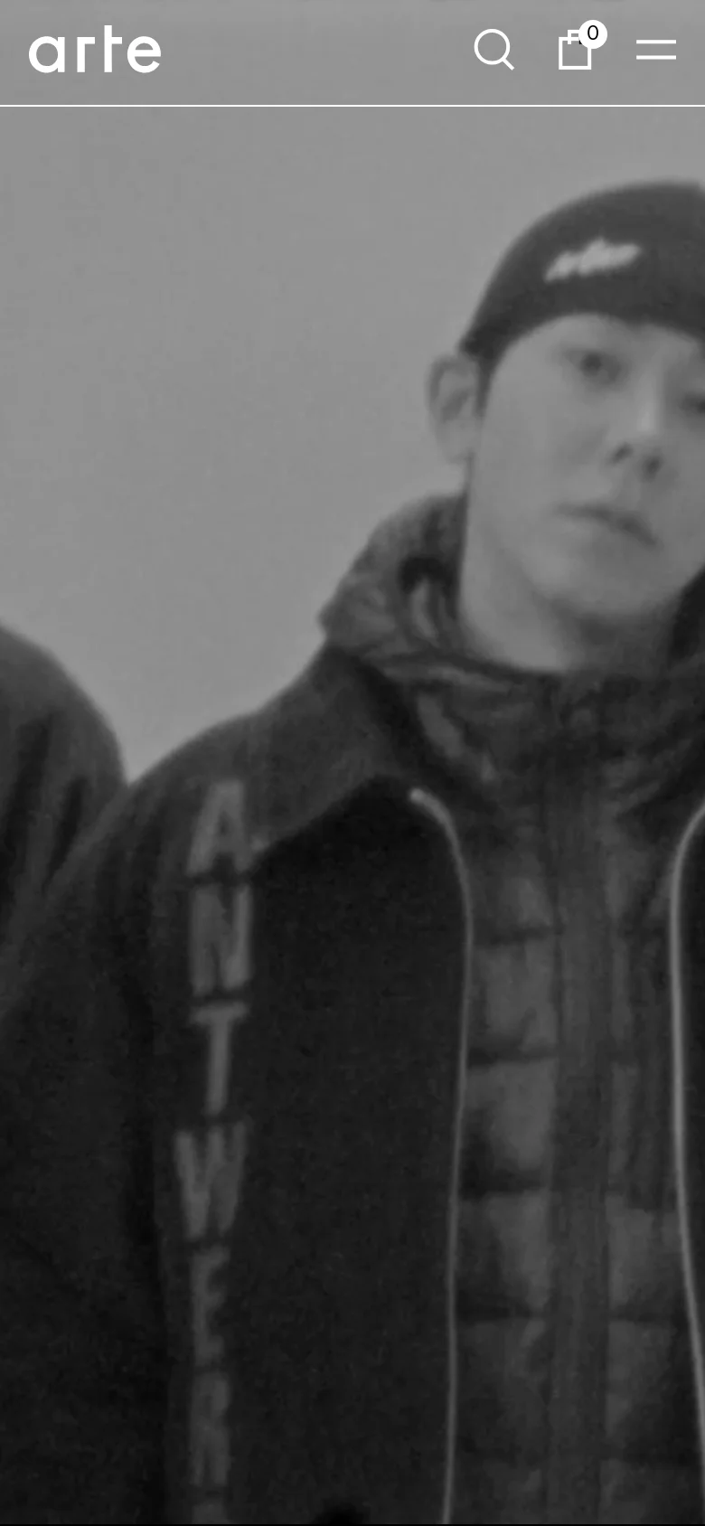 The mobile version maintains the minimalist aesthetic but uses a condensed header with a centered 'arte' logo, a search icon, a shopping bag icon, and a hamburger menu icon. The large black-and-white hero image is cropped to focus on a close-up of a person in a dark jacket. The content blocks below are stacked vertically for easy scrolling on a smaller screen.