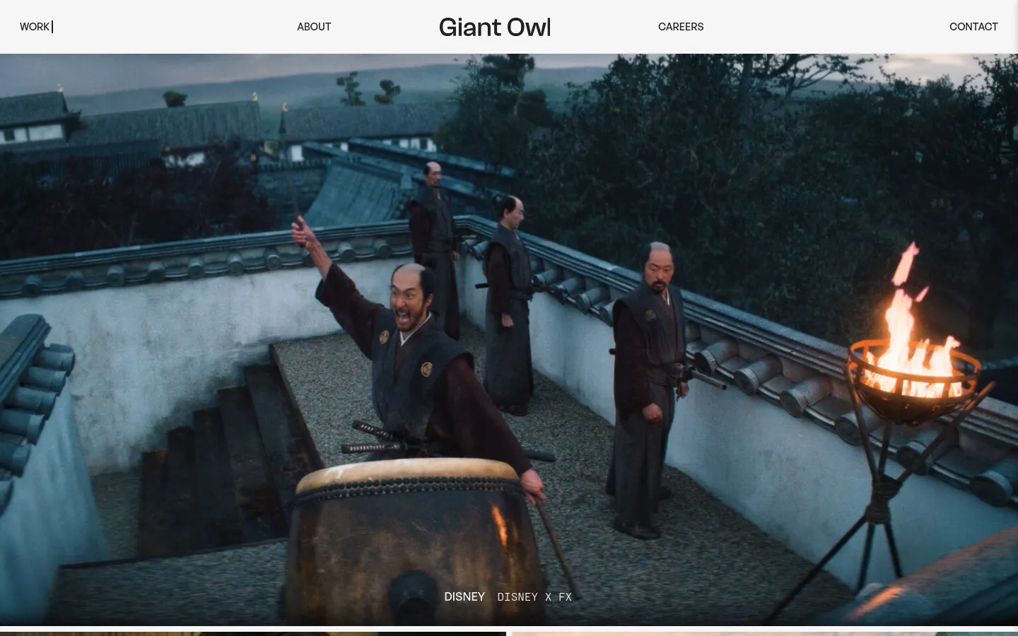 The desktop page features a minimalist white header with the 'Giant Owl' logo centered and navigation links for Work, About, Careers, and Contact. The main content area displays a large, cinematic hero image of characters on a rooftop, overlaid with the text 'DISNEY DISNEY X FX'. Below the hero, a grid of large, high-quality video thumbnails showcases various creative projects with white text overlays.